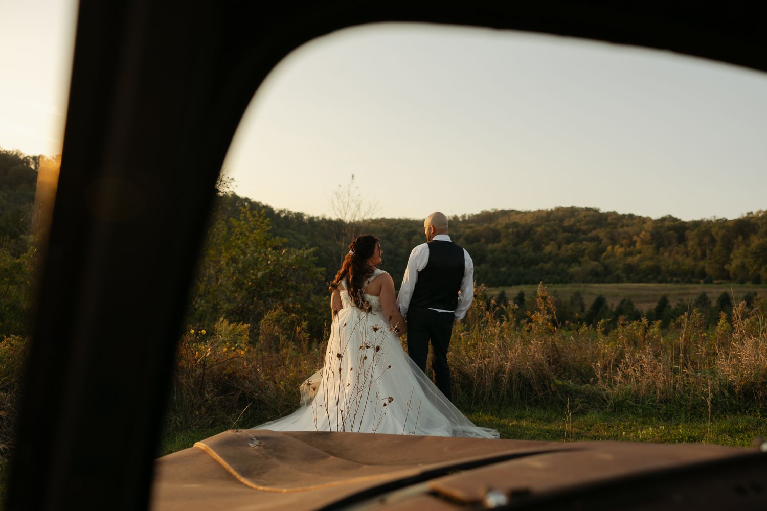 Golden hour wedding photography with couple silhouetted against mountain landscape.