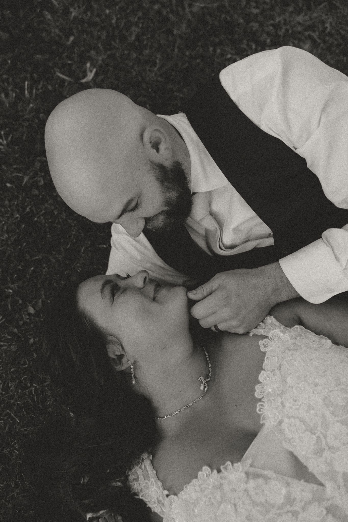 Intimate black and white portrait of newlyweds sharing a tender moment.