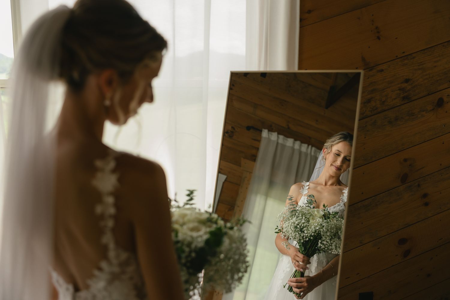 Sunlit wedding preparation moments captured through window reflections.