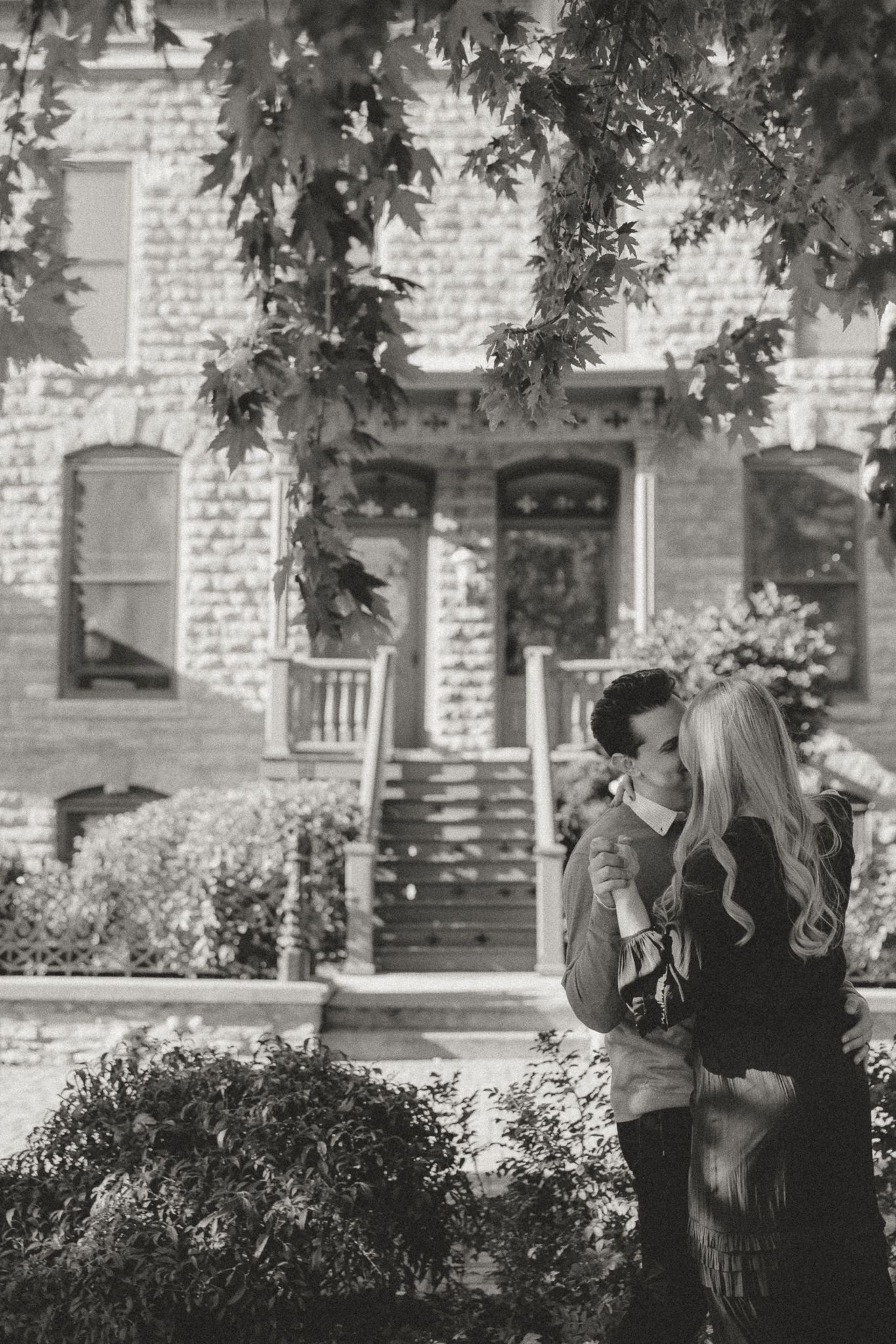 Black and white series of a couple's intimate moments beneath tree branches.