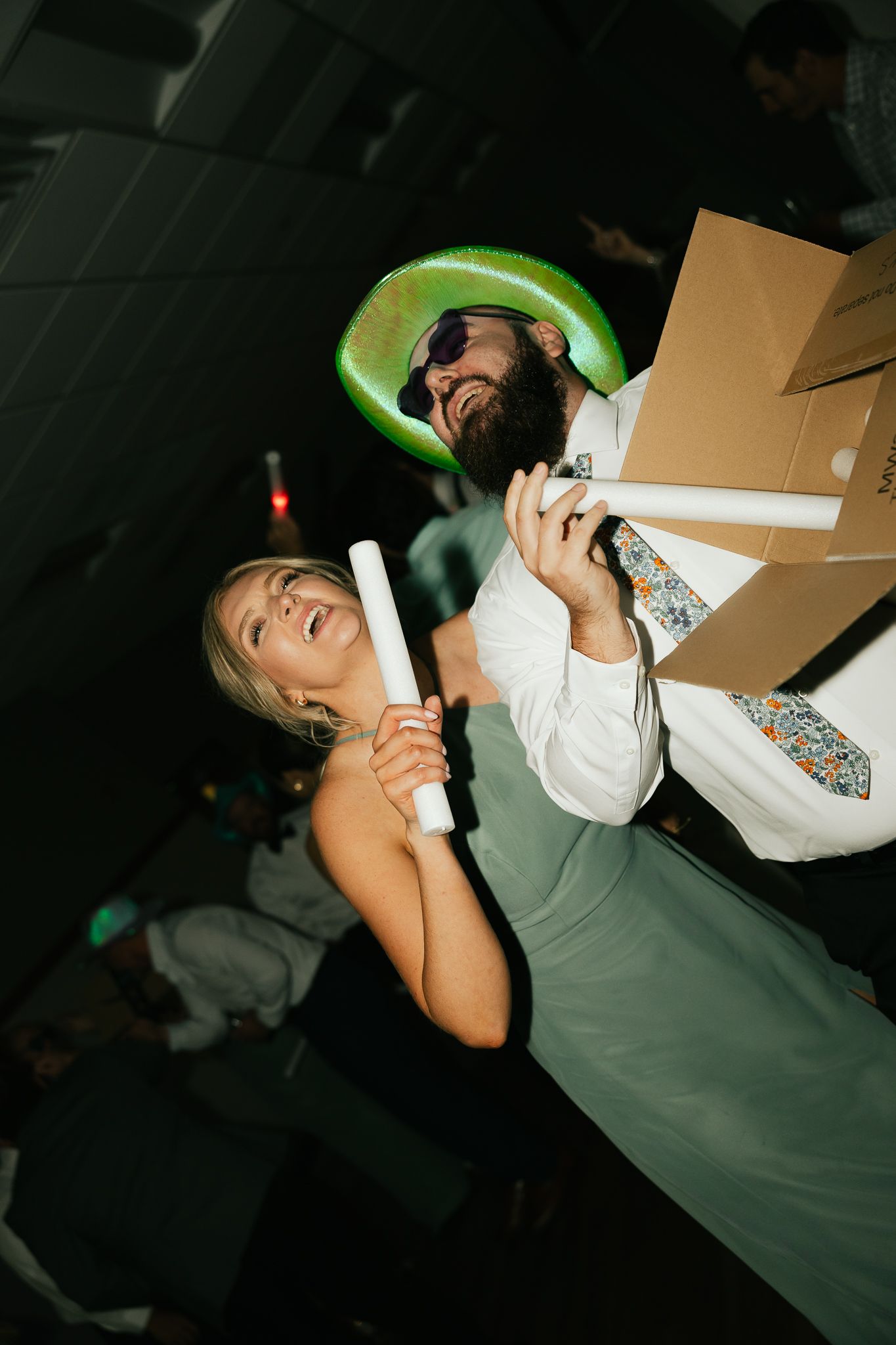 Guests in formal attire dancing energetically at a nighttime celebration.