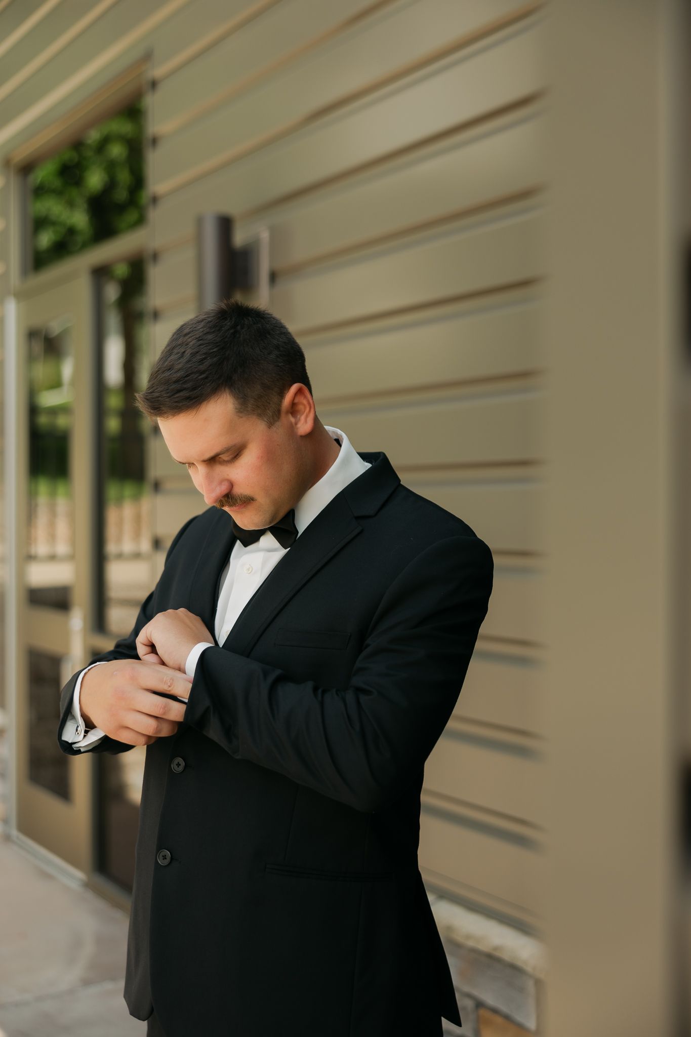 Groom in black suit adjusting his tie in a sequence of photos.