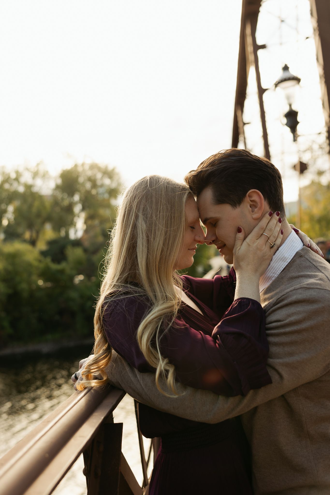 Romantic sunset moment between couple on bridge with warm golden light.