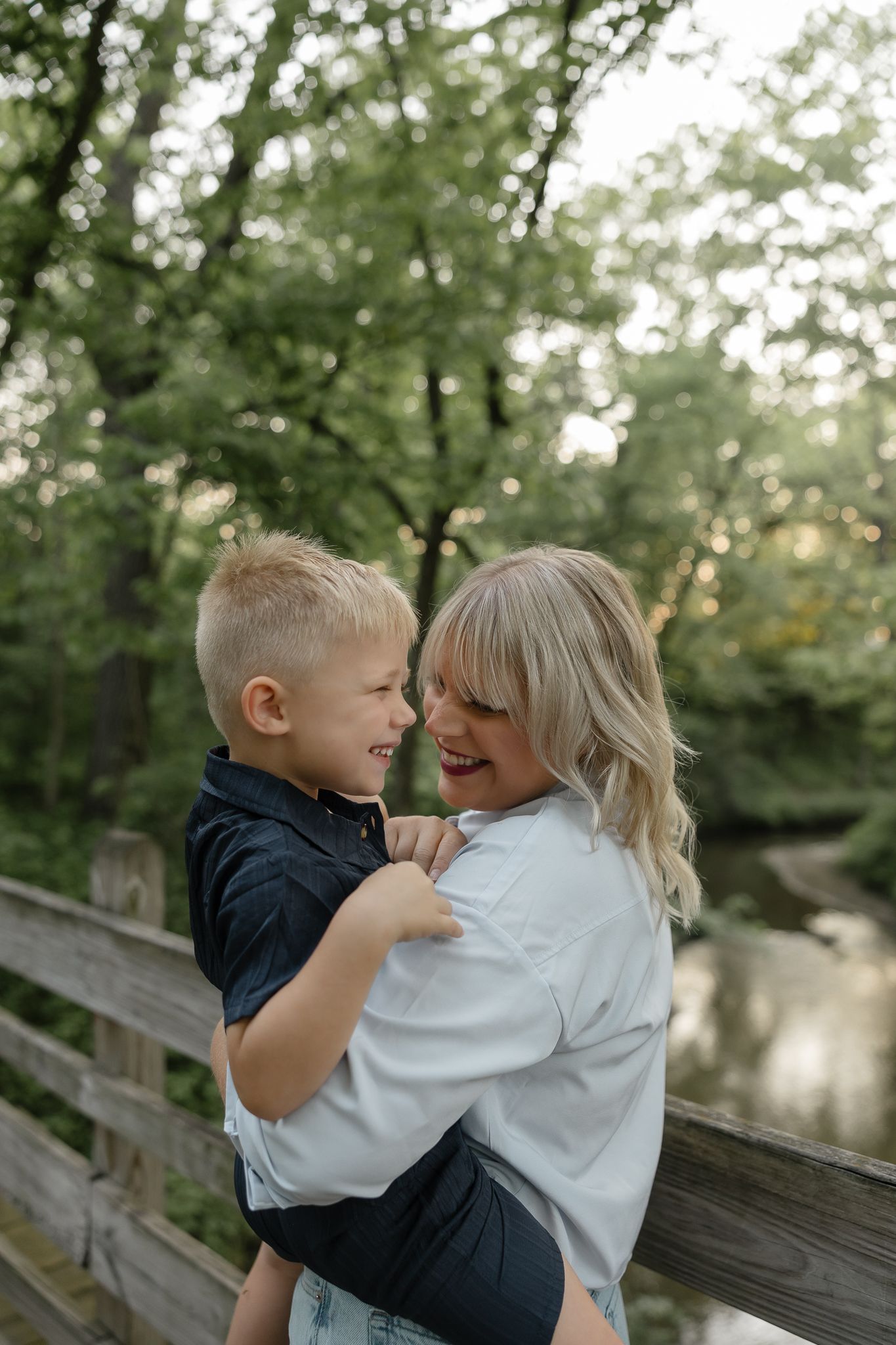 A heartwarming moment between a child and adult sitting on a wooden deck by a lake.