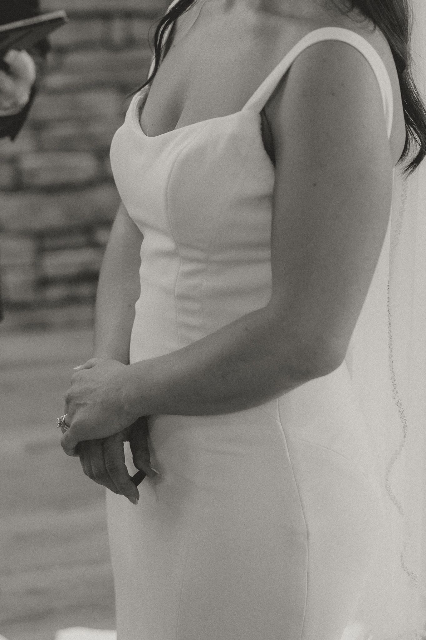 Side view of bride in elegant white dress during wedding ceremony.
