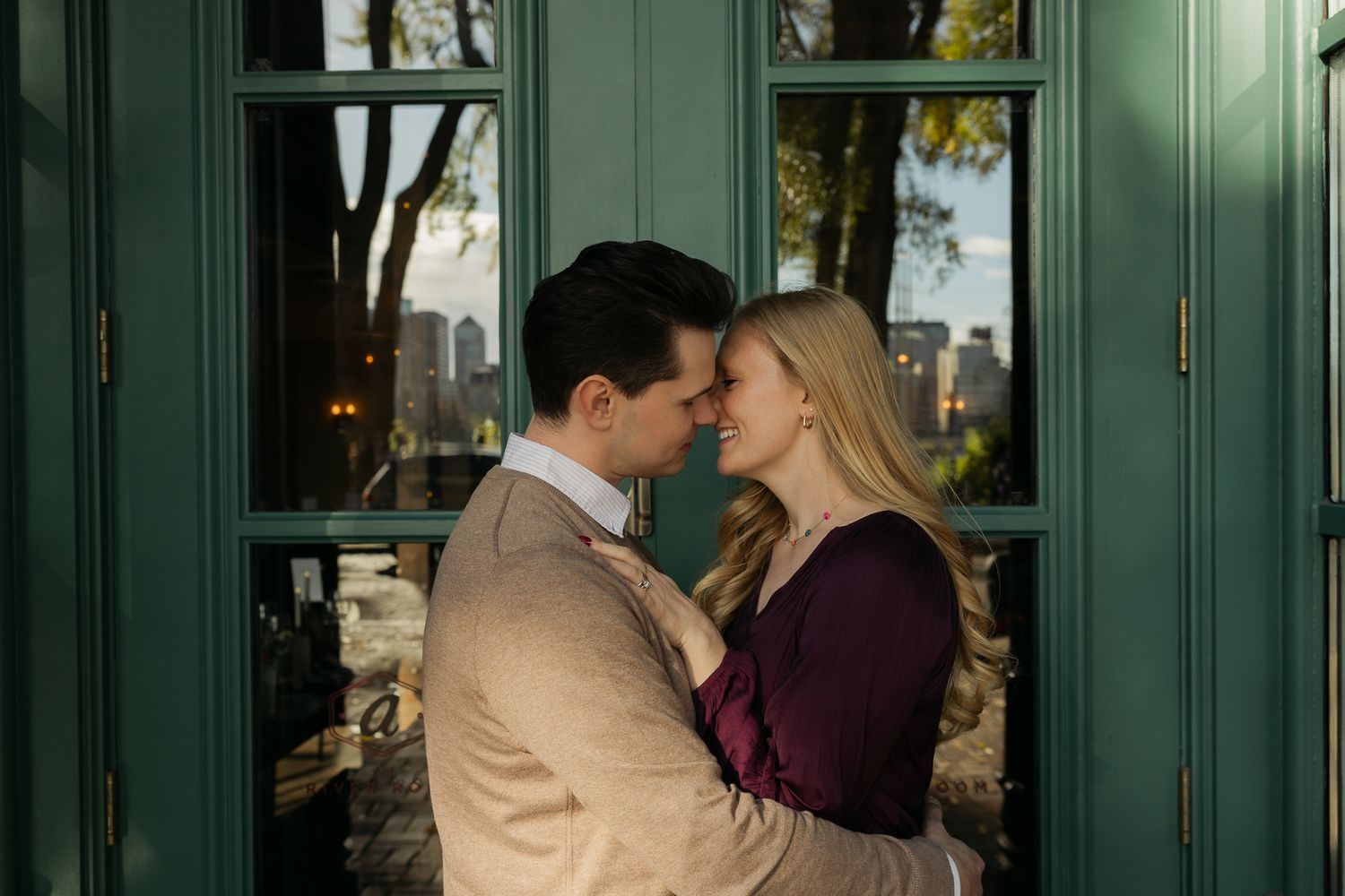 A romantic moment captured in front of green-painted architectural details.