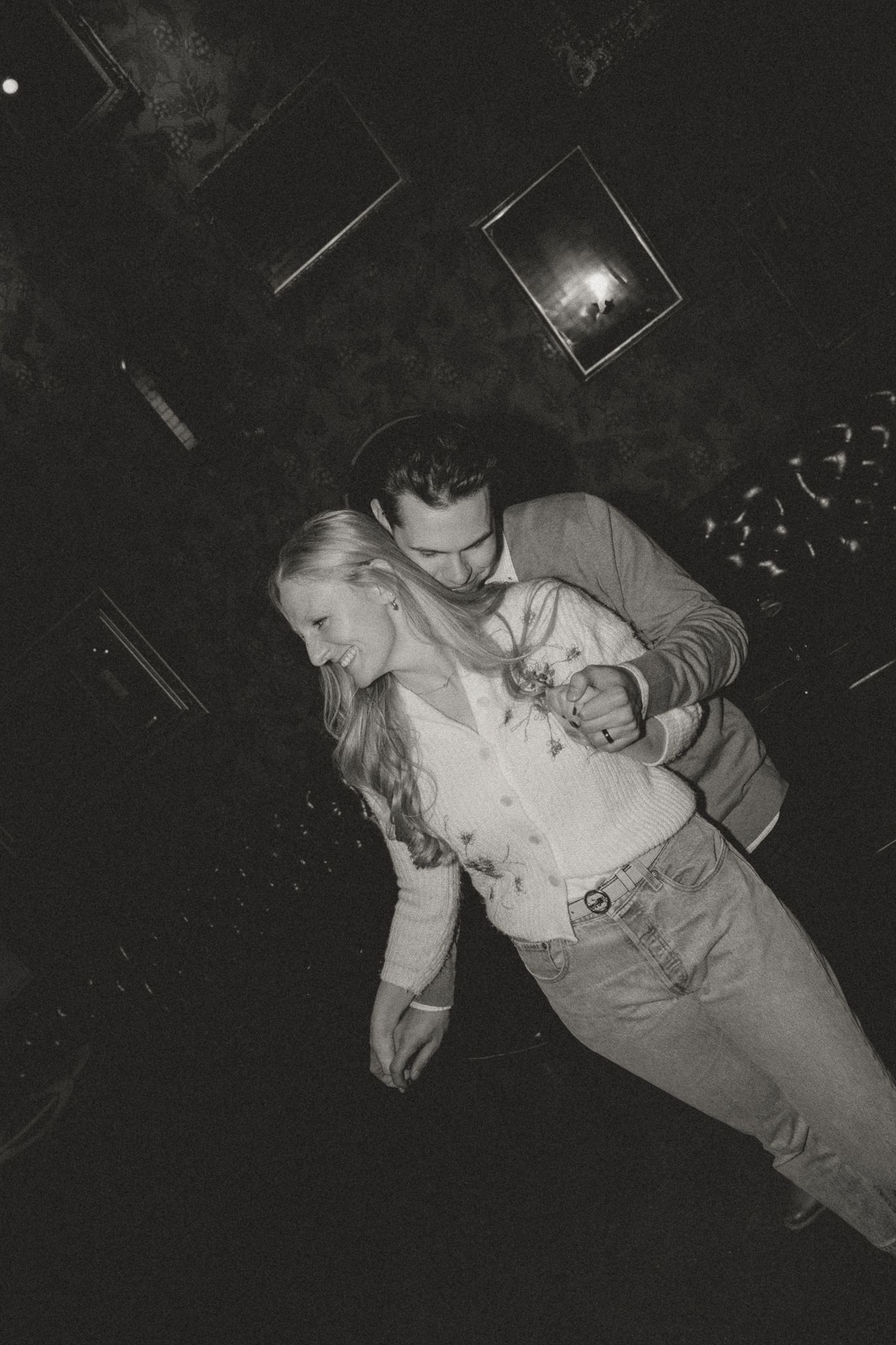 Black and white nightclub photo showing dancing couple in casual attire.