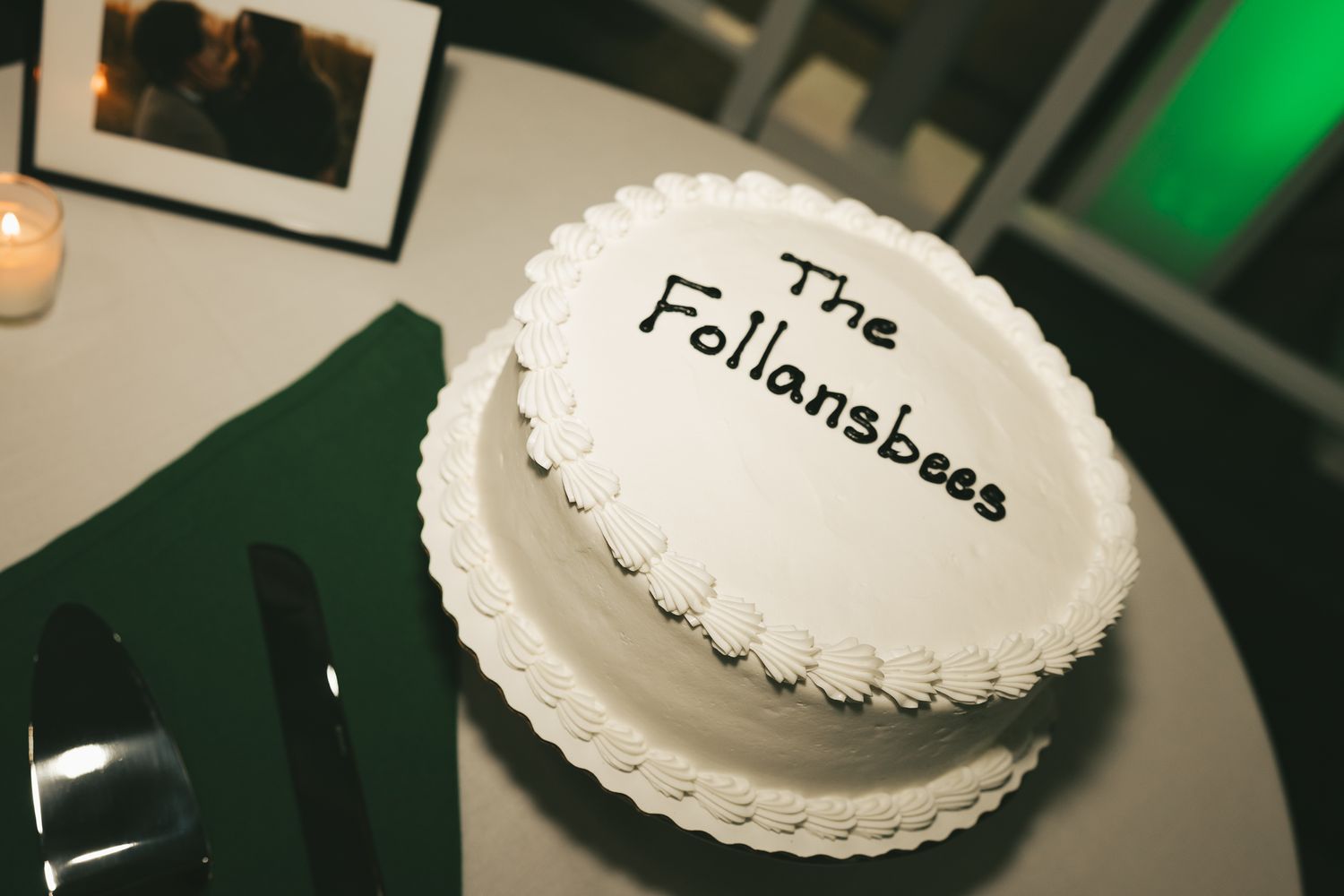 Close-up shot of a white wedding cake with text on top.