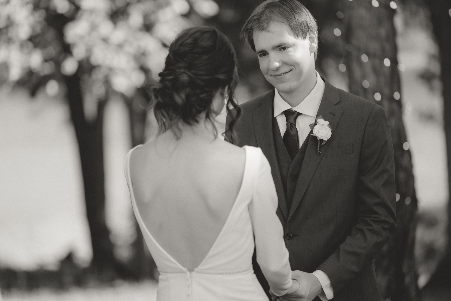 Elegant outdoor wedding ceremony with bokeh lights and natural backdrop.