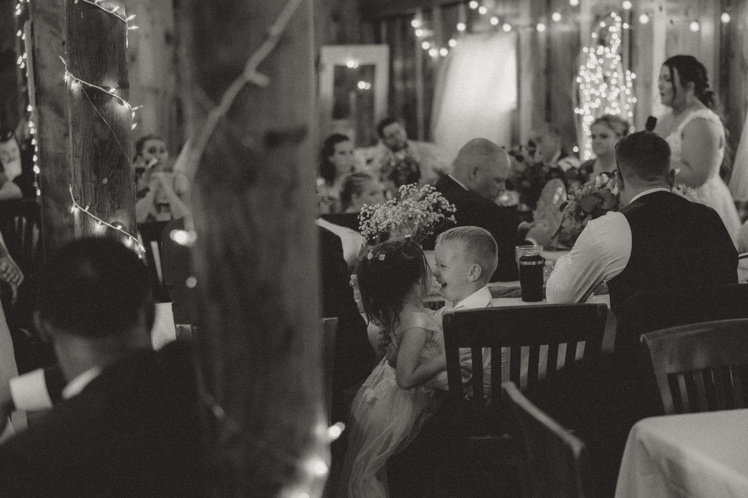 Wedding reception venue decorated with twinkling lights and tables set for celebration.
