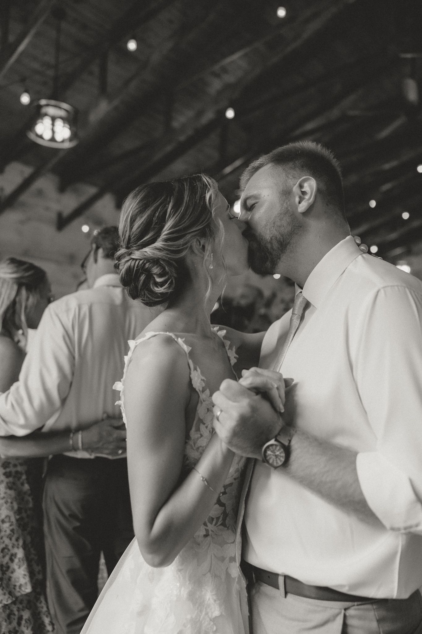 Black and white photograph of a romantic first dance at an indoor reception.