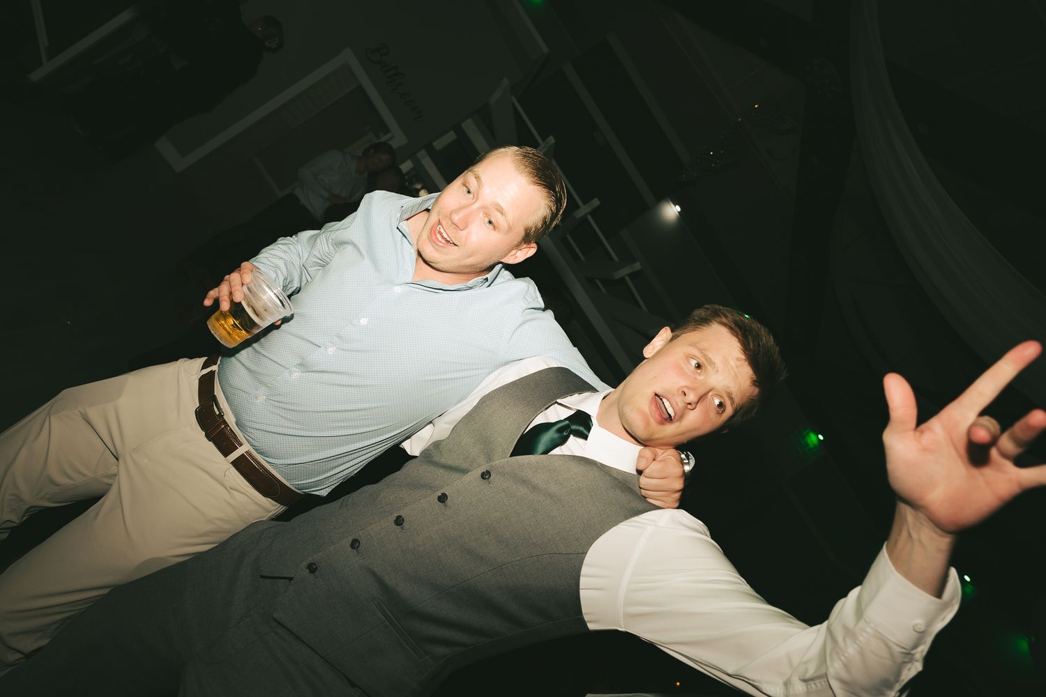 Two guests strike playful poses during a nighttime celebration.