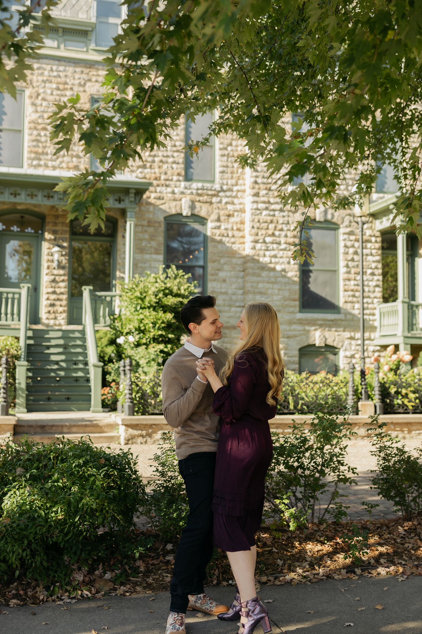 Romantic sequence of a couple sharing affectionate moments outside a historic stone building.