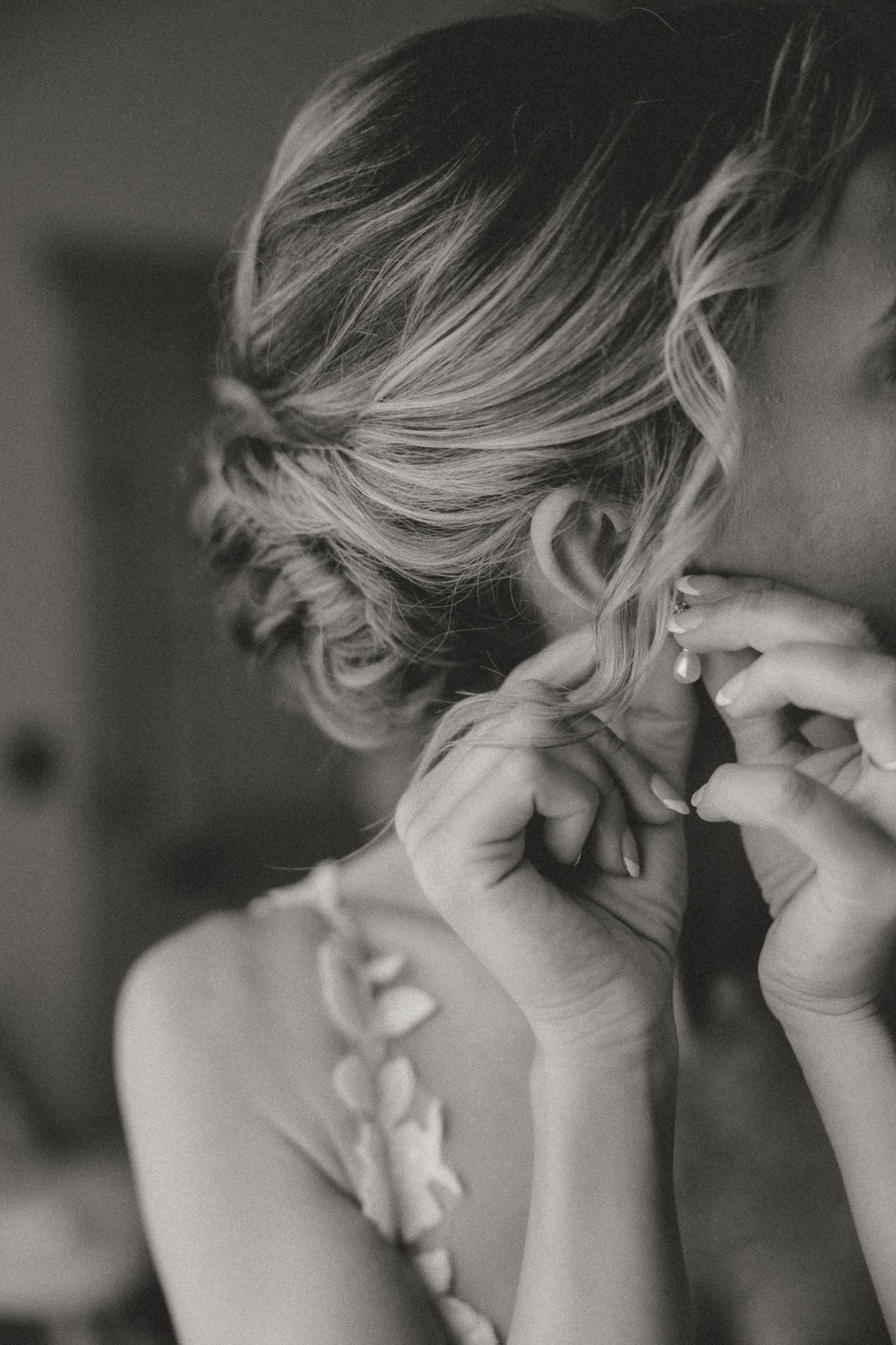Close-up sequence of putting on earrings during wedding preparations.