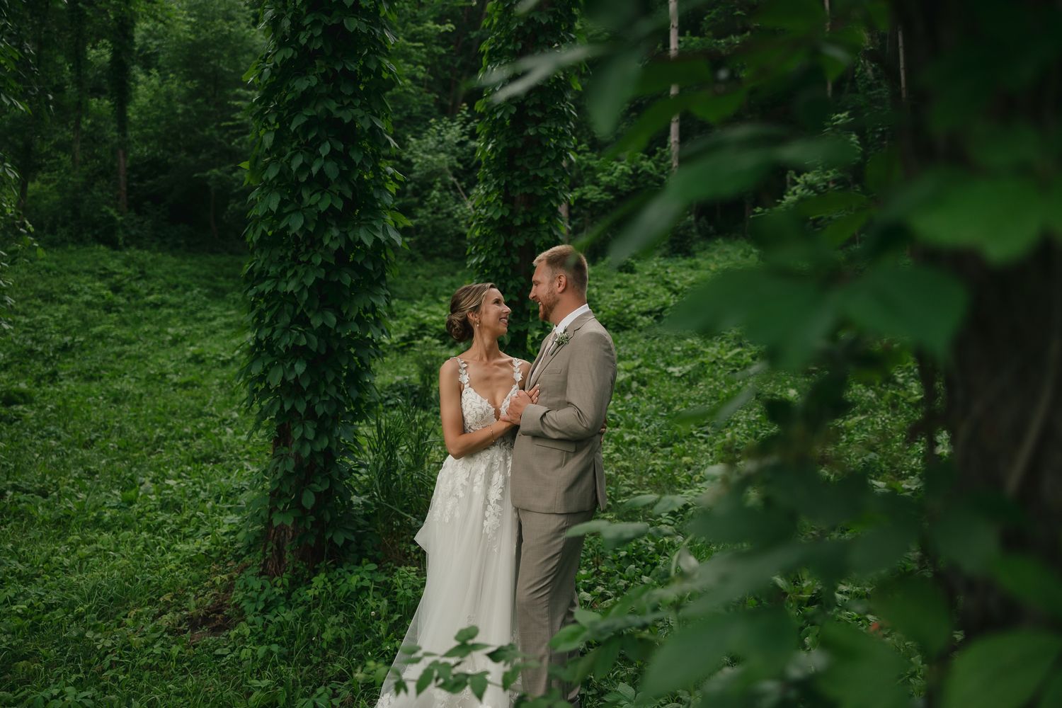 Wedding photography session in a secluded forest with lush green backdrop.