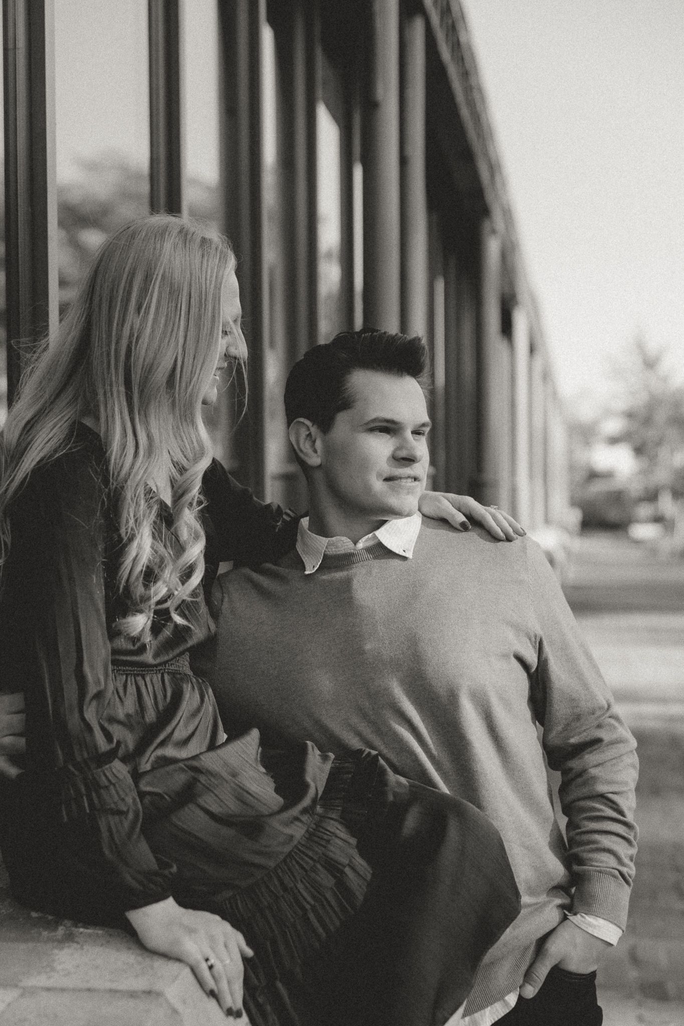 Black and white portrait series of couple in casual attire sharing intimate moments.