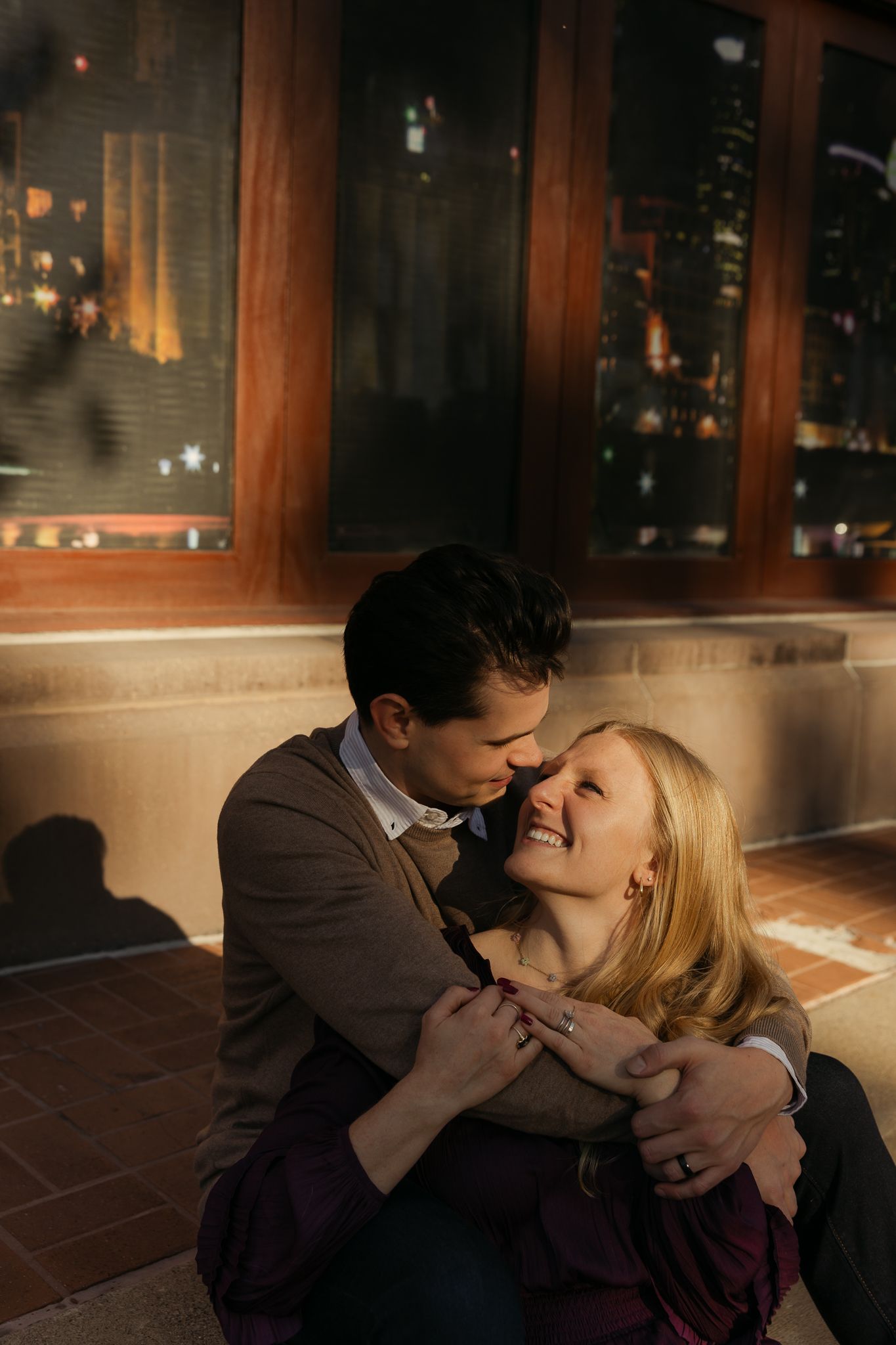 A romantic couple sharing an intimate kiss in a dimly lit indoor setting.