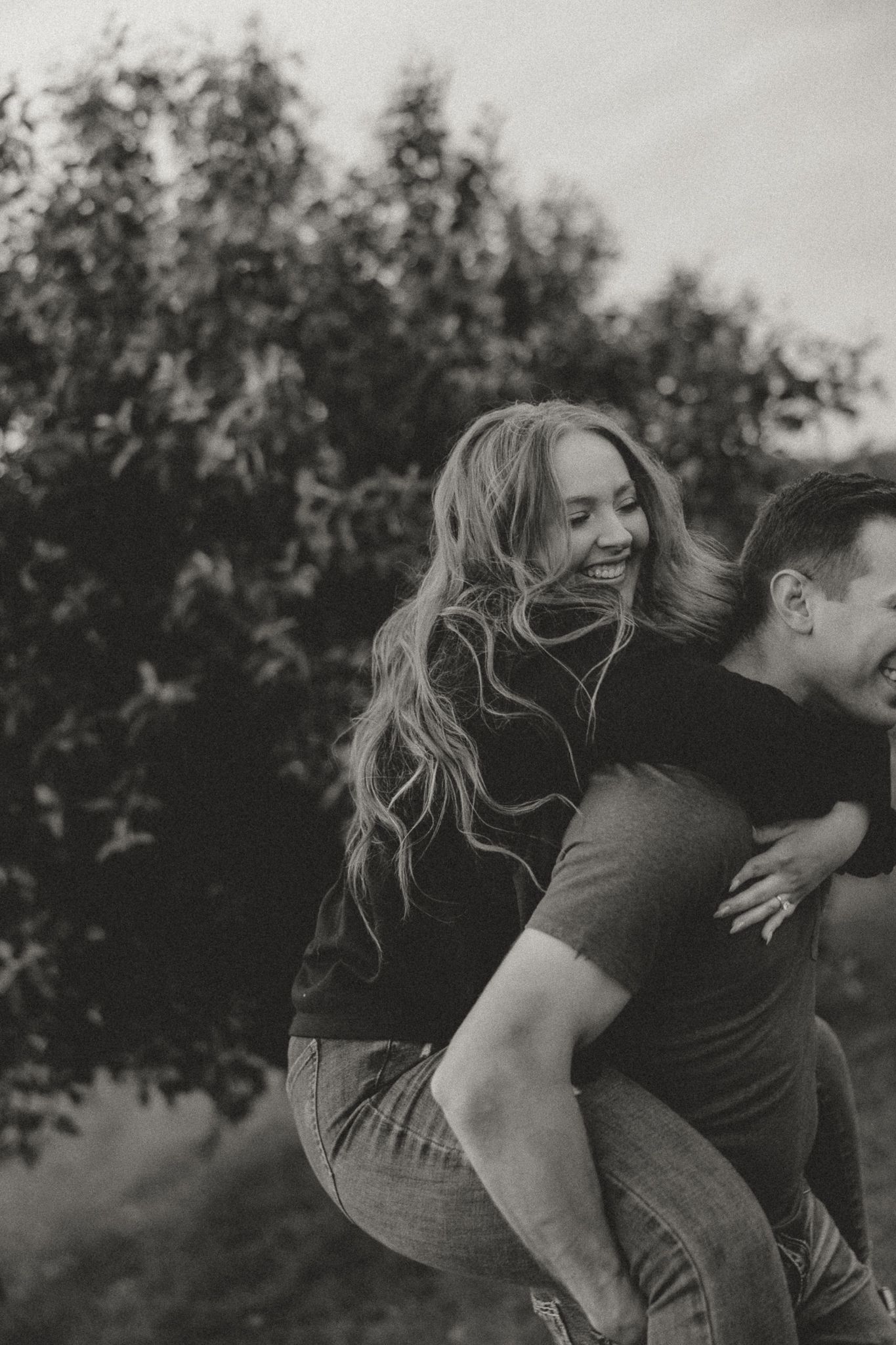 A playful piggyback ride moment captured in black and white photography.