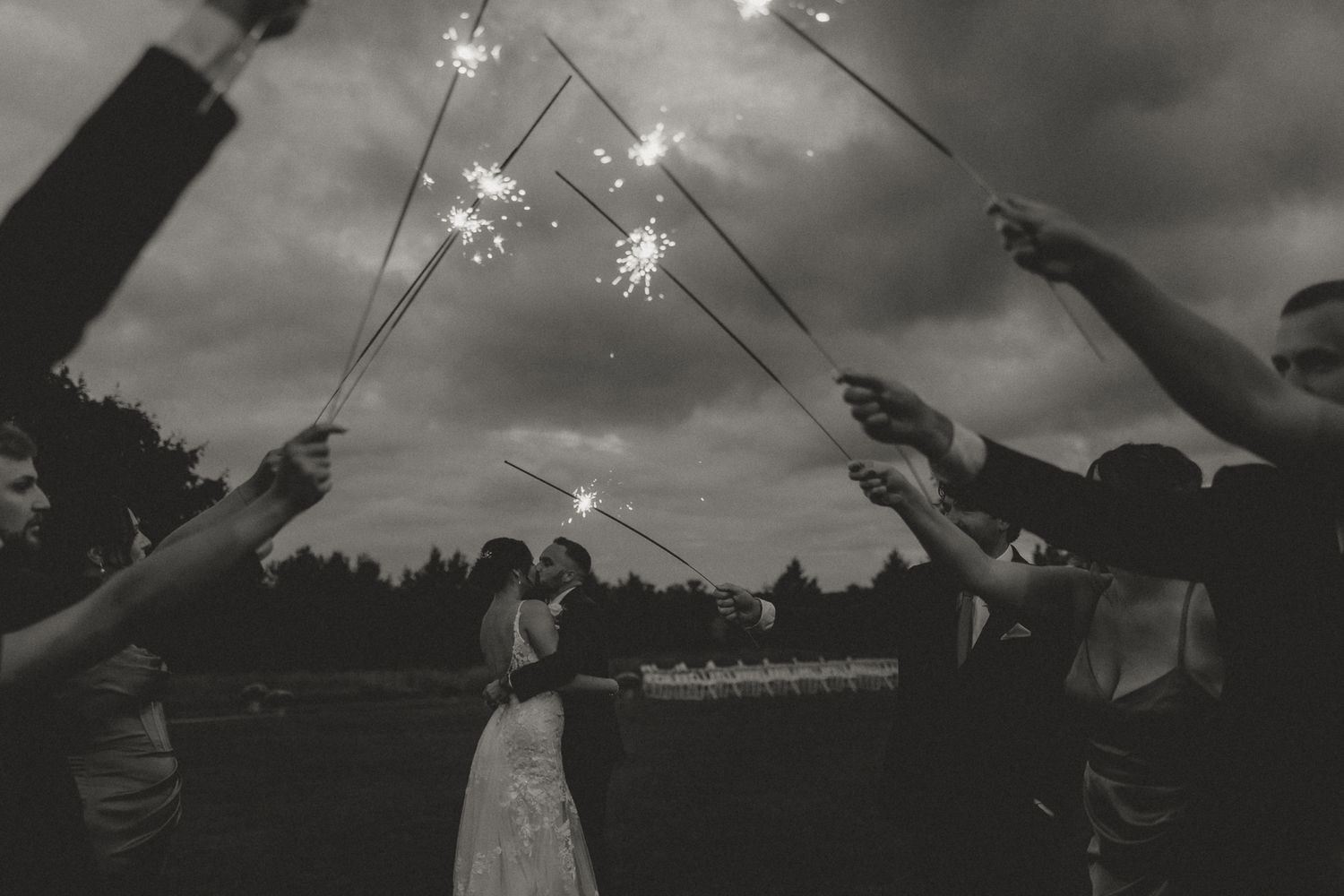 Sparklers create a magical nighttime display with glowing trails against a dark sky.