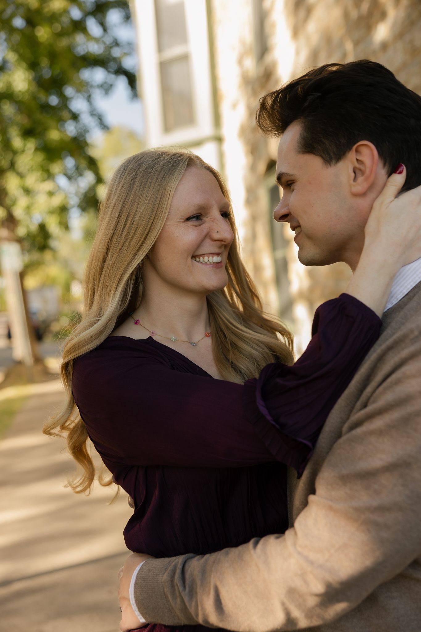Romantic couple sharing tender moments in a series of outdoor photos with sunlit trees in the background.