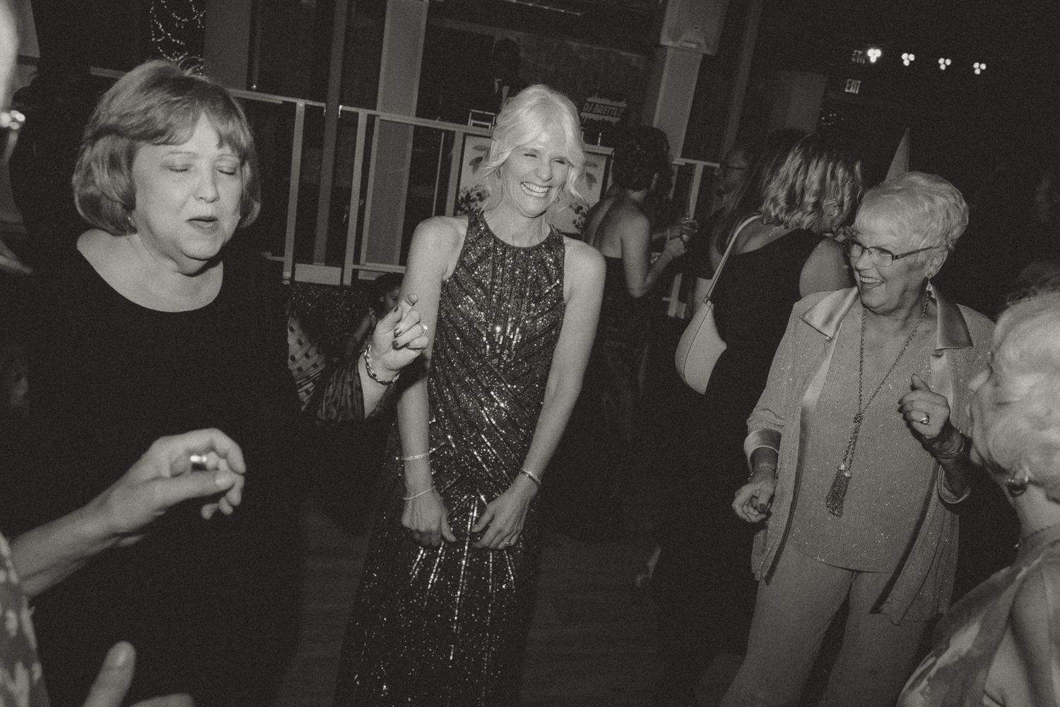 Black and white photo of guests dancing and celebrating at a party.