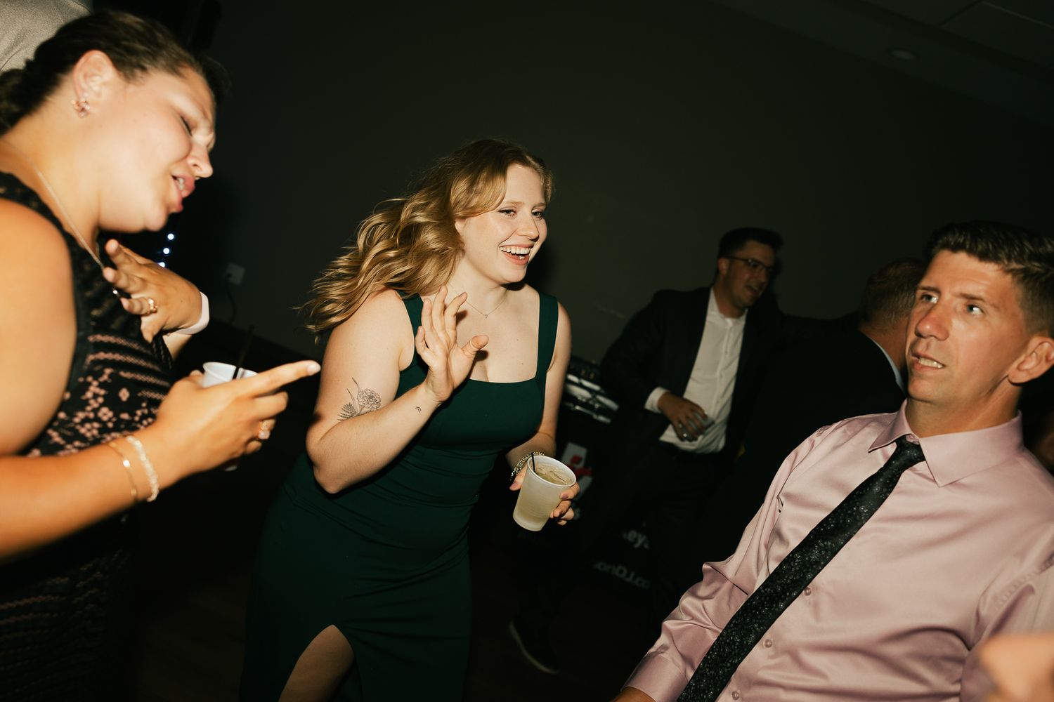 Wedding guests dancing and socializing at a nighttime reception.