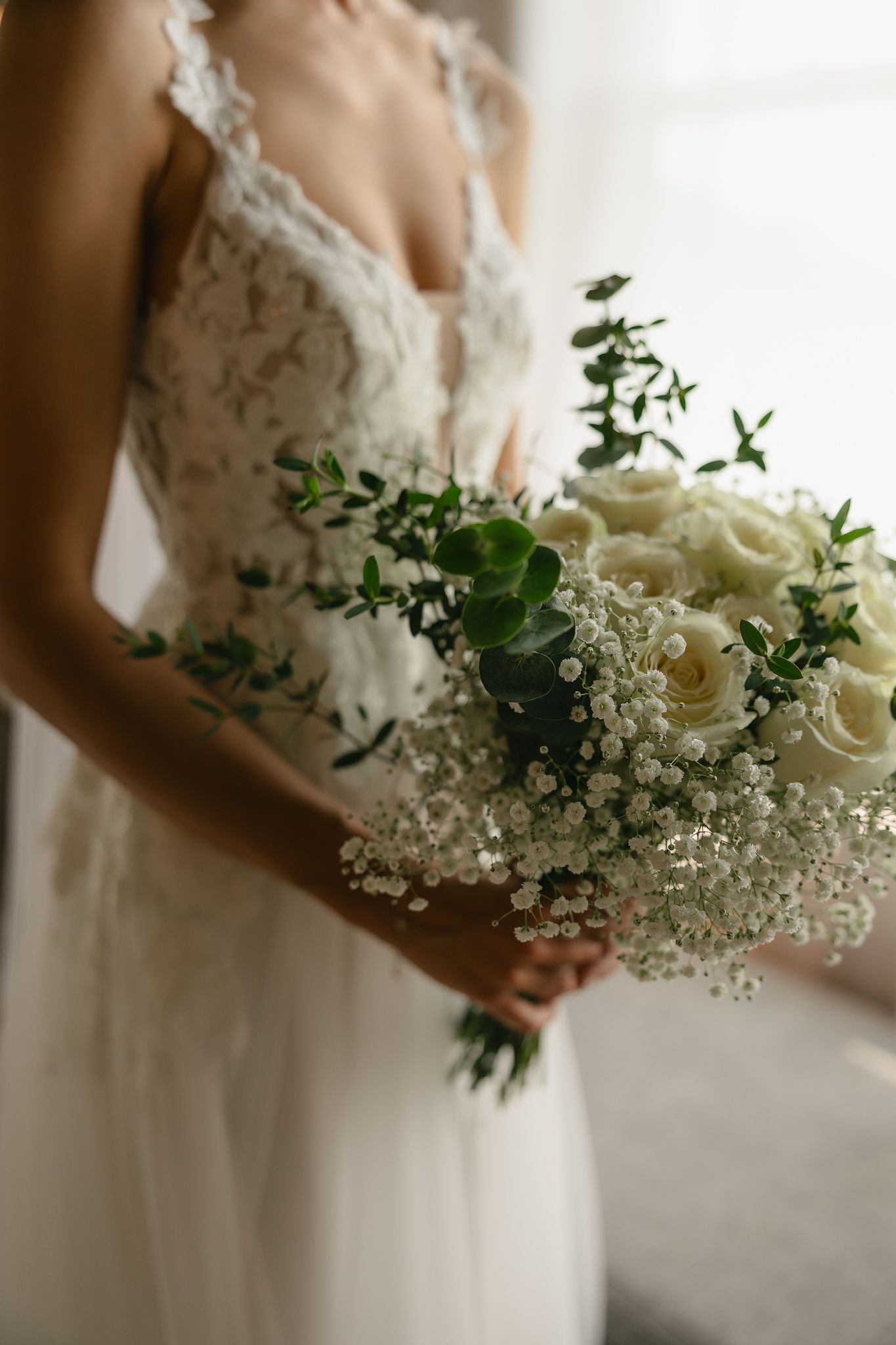 Elegant white and green wedding bouquet with baby's breath and roses.
