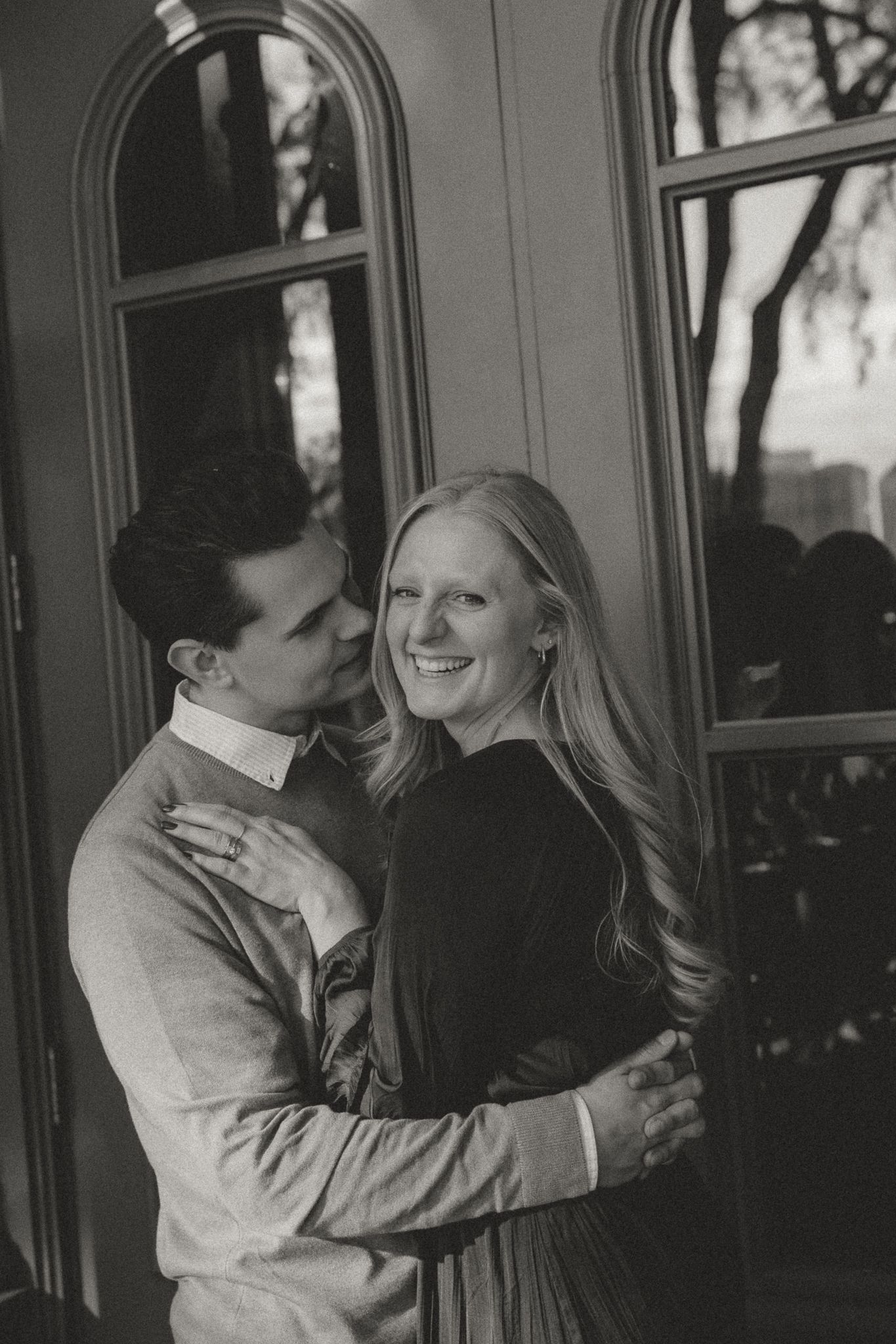 A black and white photograph capturing an intimate moment between two people.