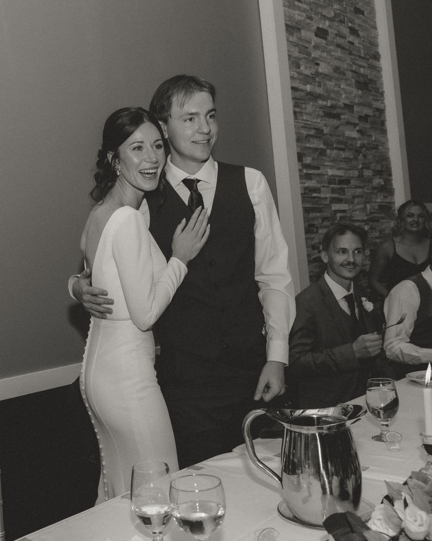 Couple sharing a joyful moment during their wedding reception at a decorated venue.