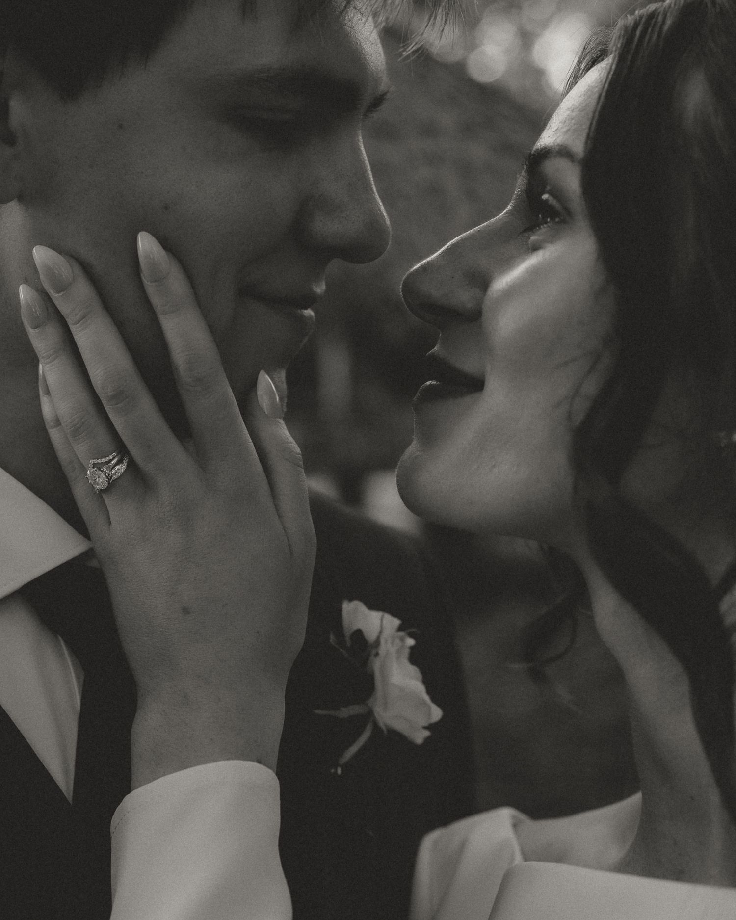 A black and white close-up captures an intimate wedding moment.