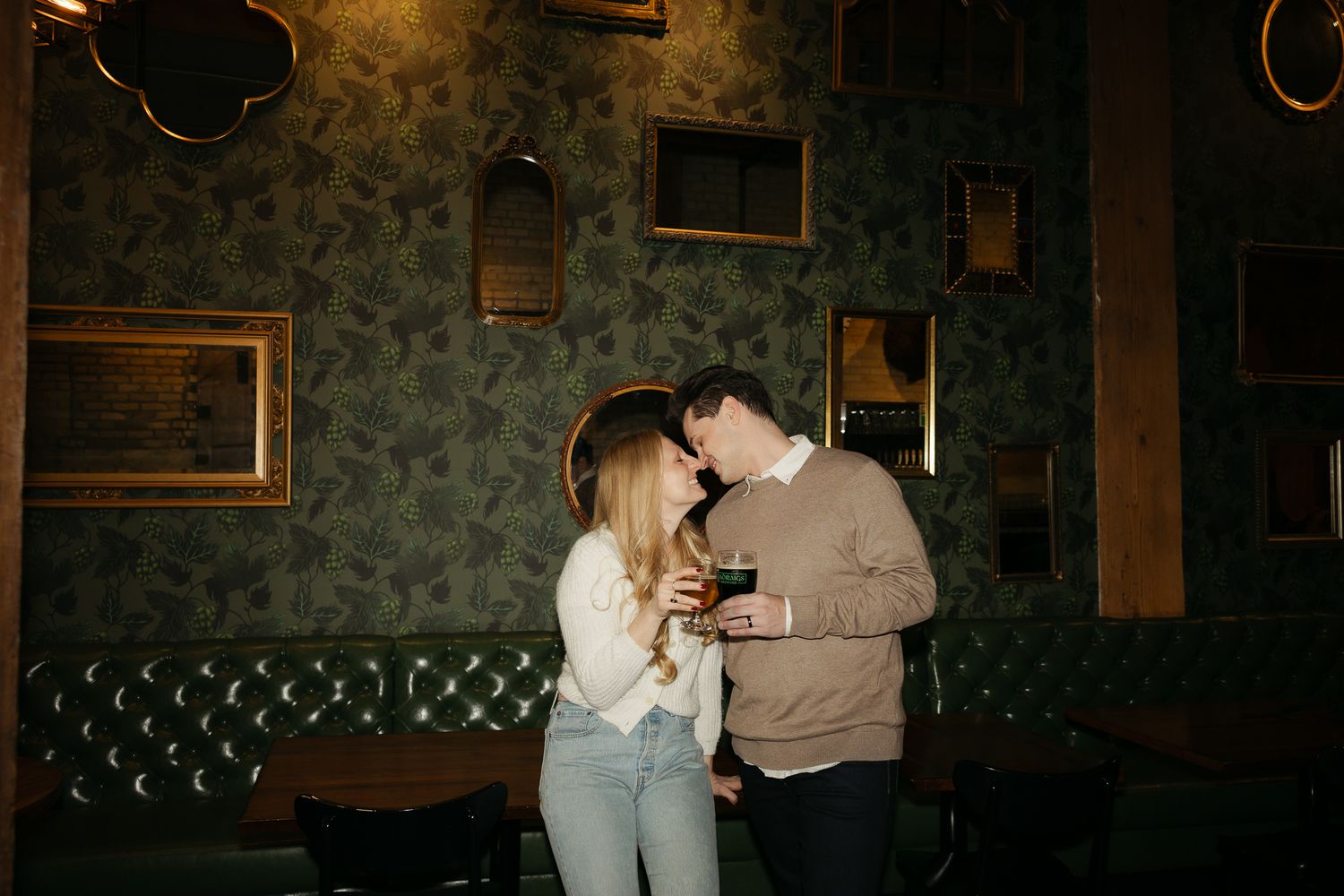 Intimate moment captured in dimly lit bar with vintage decor and leather seating.