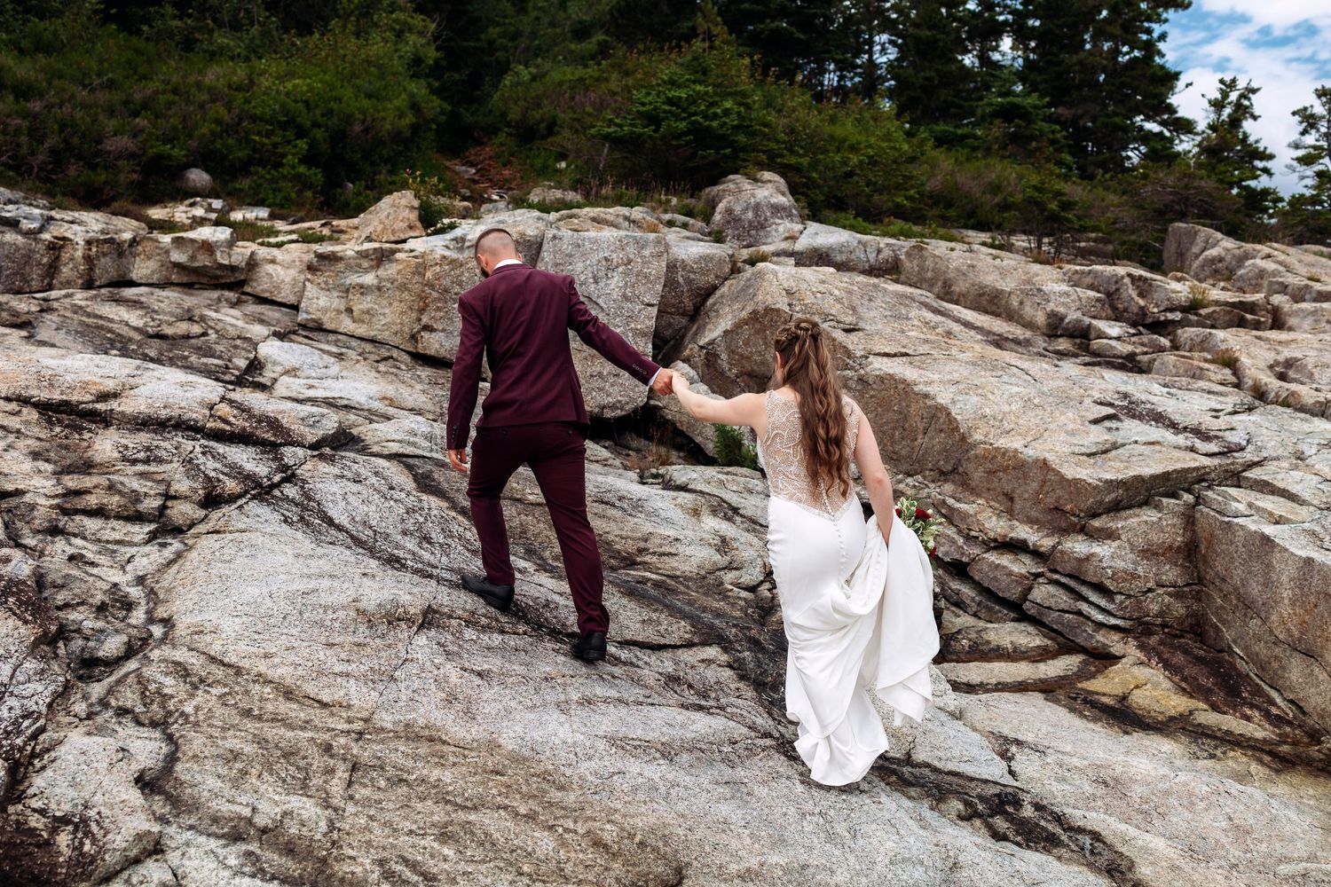 Newlyweds walking away from ceremony into sunset light