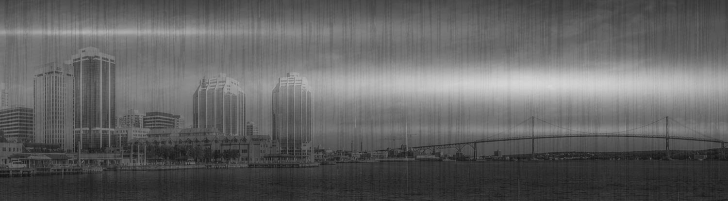 Grayscale panoramic cityscape with skyscrapers and a bridge over water under an overcast sky.