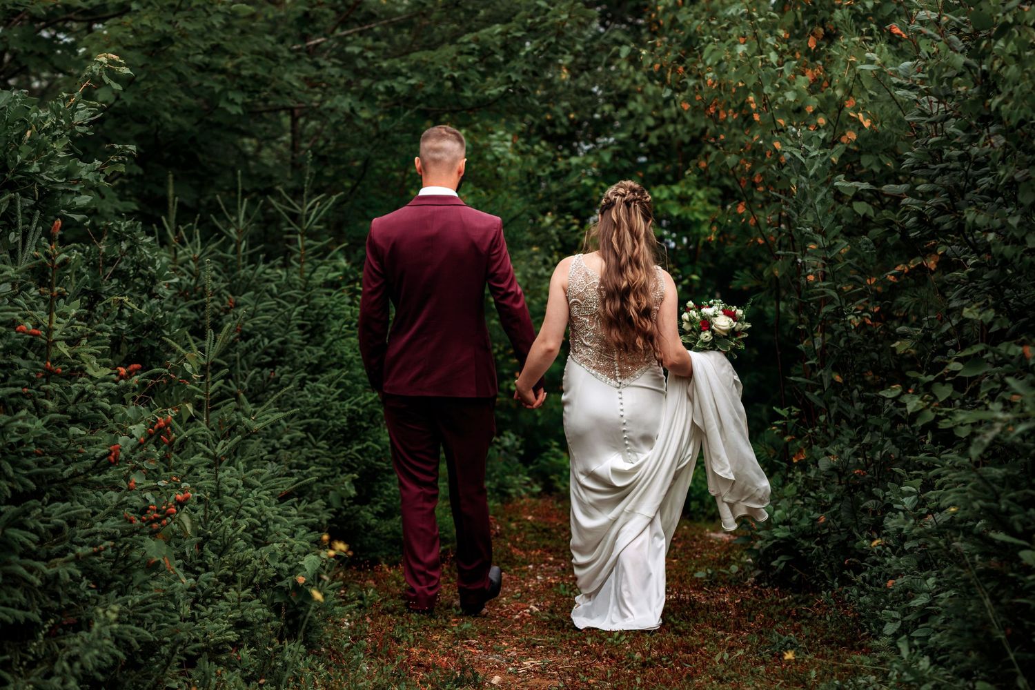 Newlyweds walking away from ceremony into sunset light