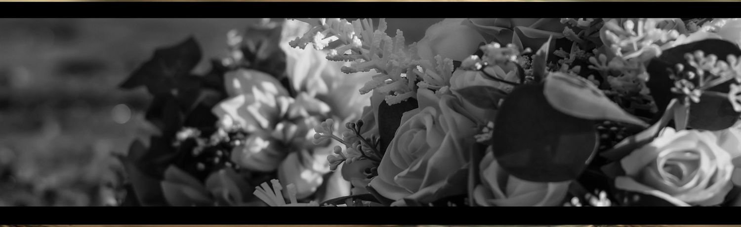 Black and white close-up photo of a beautiful floral arrangement featuring roses and mixed blooms.