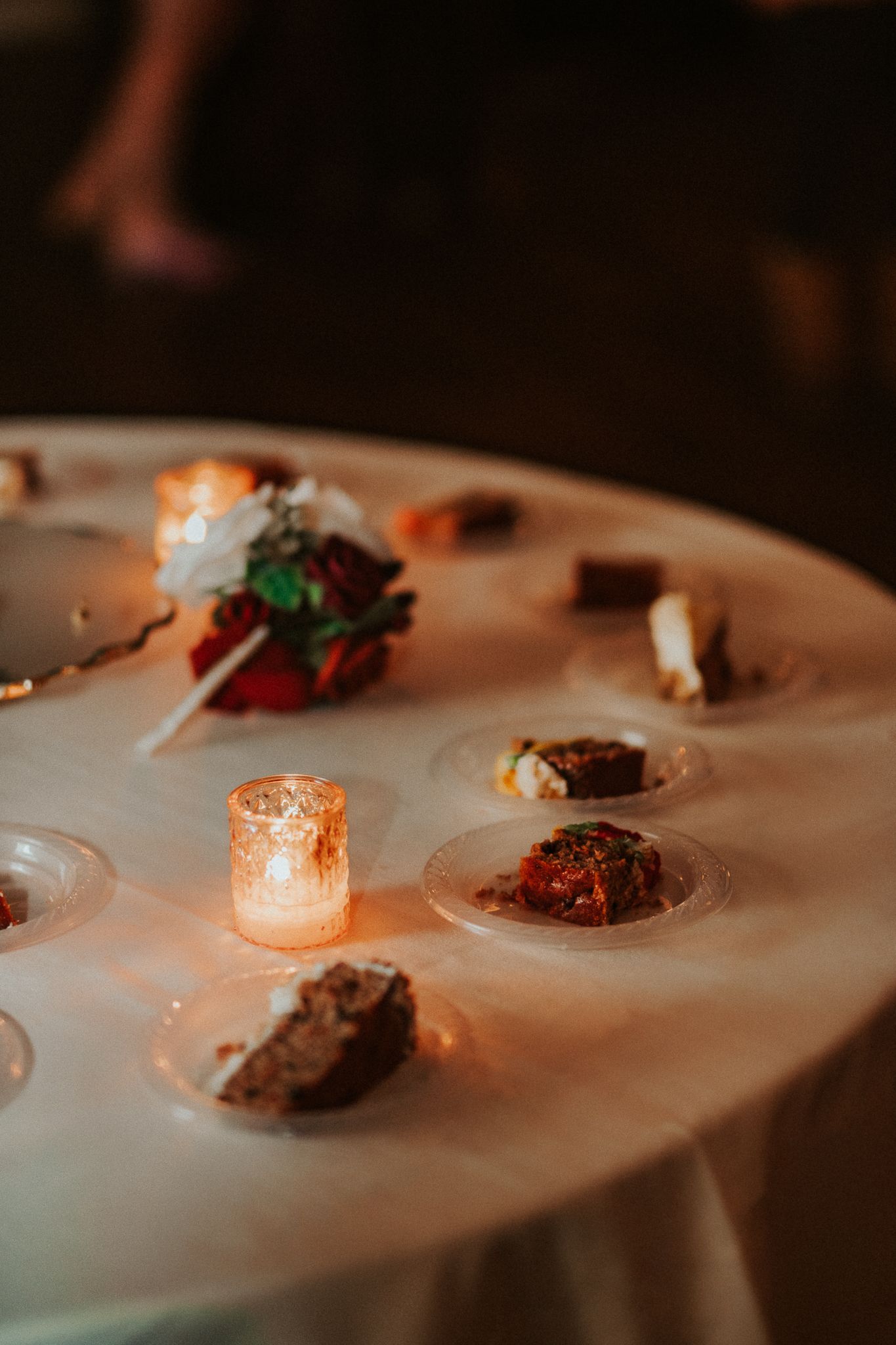 Elegant plated appetizers and candles on a white tablecloth at a formal dinner event.