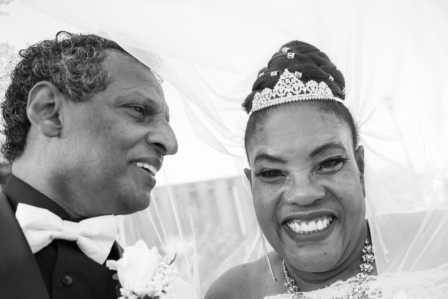 A series of candid black and white wedding photos showing joyful moments between the couple.