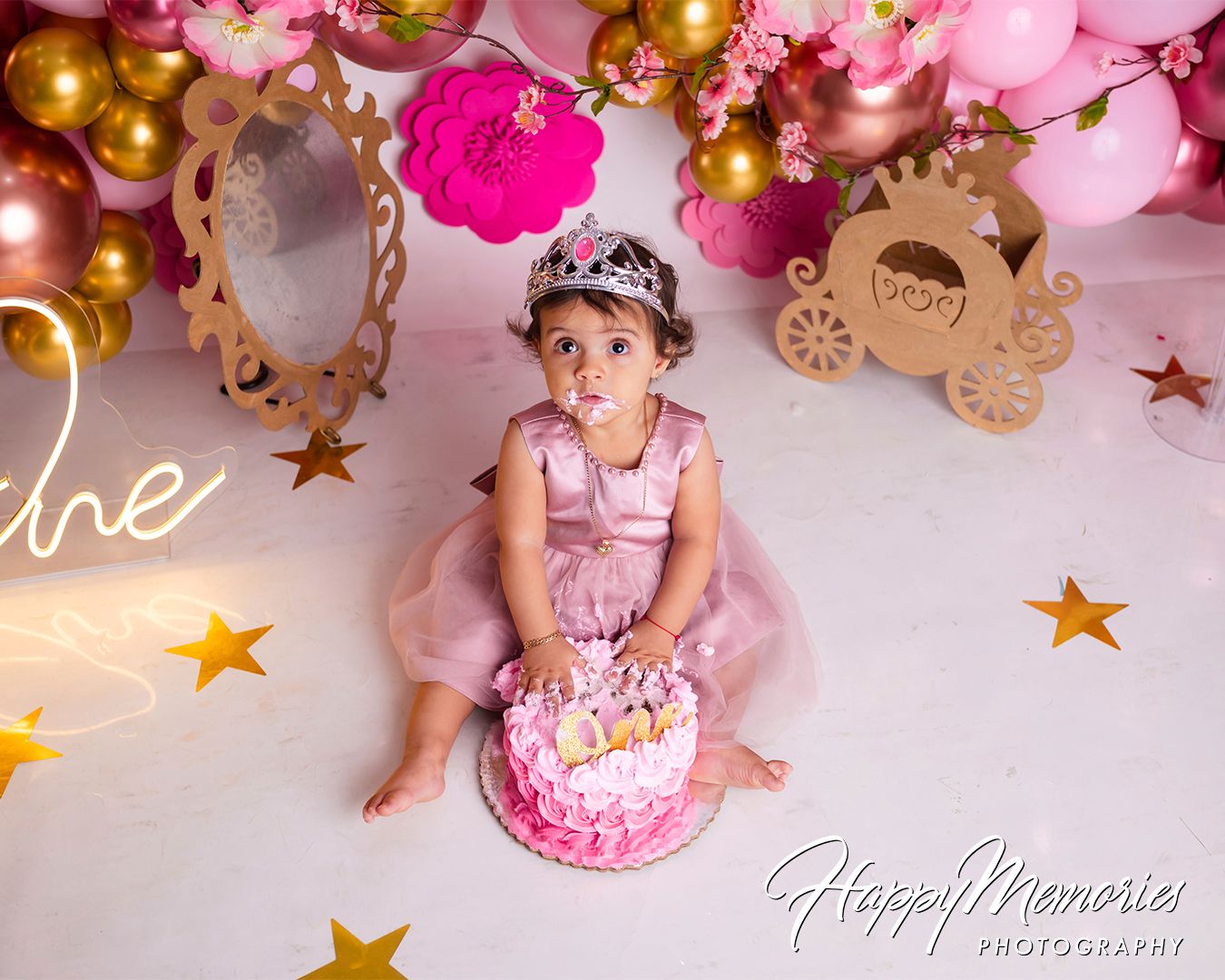 Pink and gold princess themed birthday setup with stars, crowns, and elegant balloon decorations.