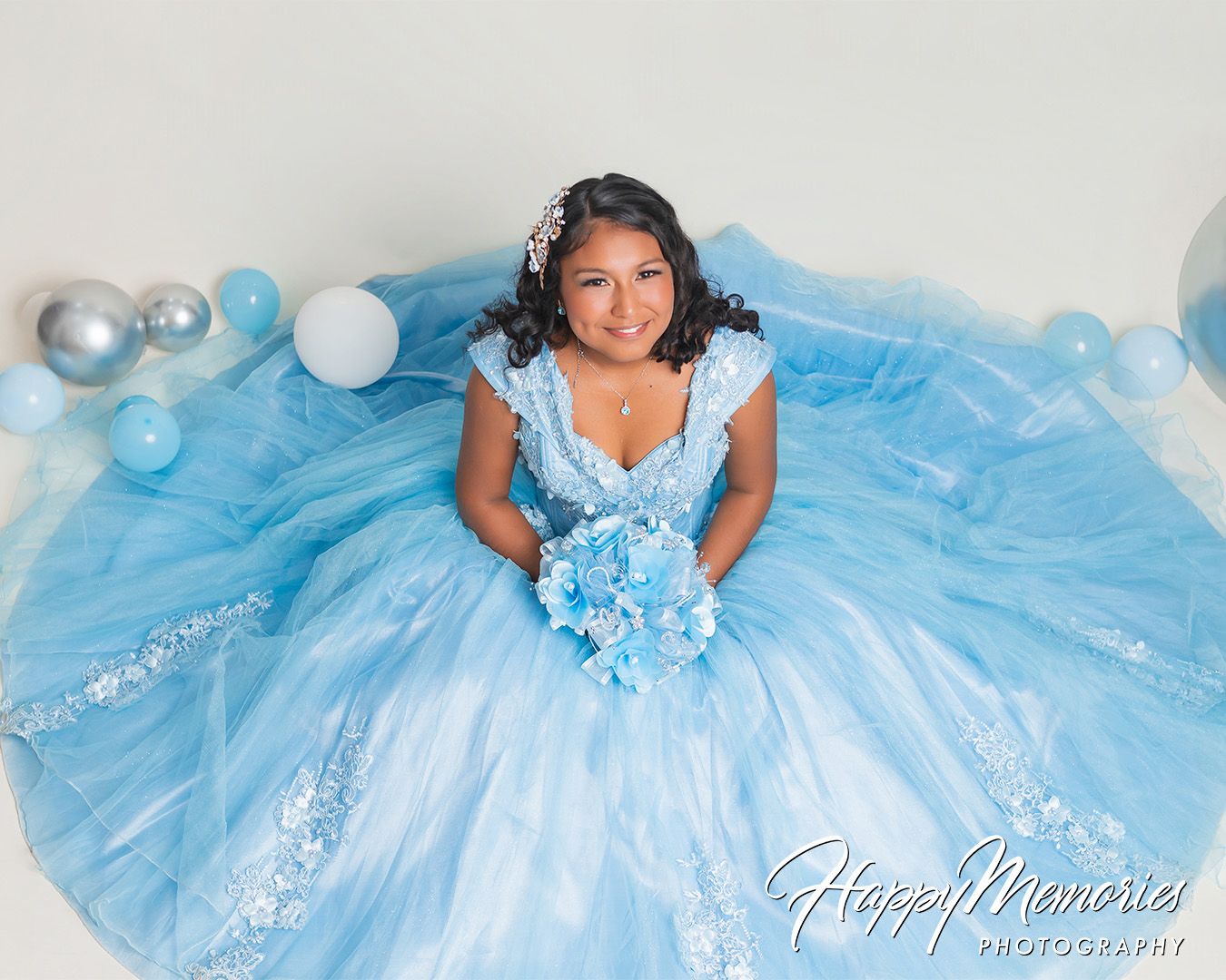 Elegant quinceañera portrait session featuring a princess-style light blue tulle gown.