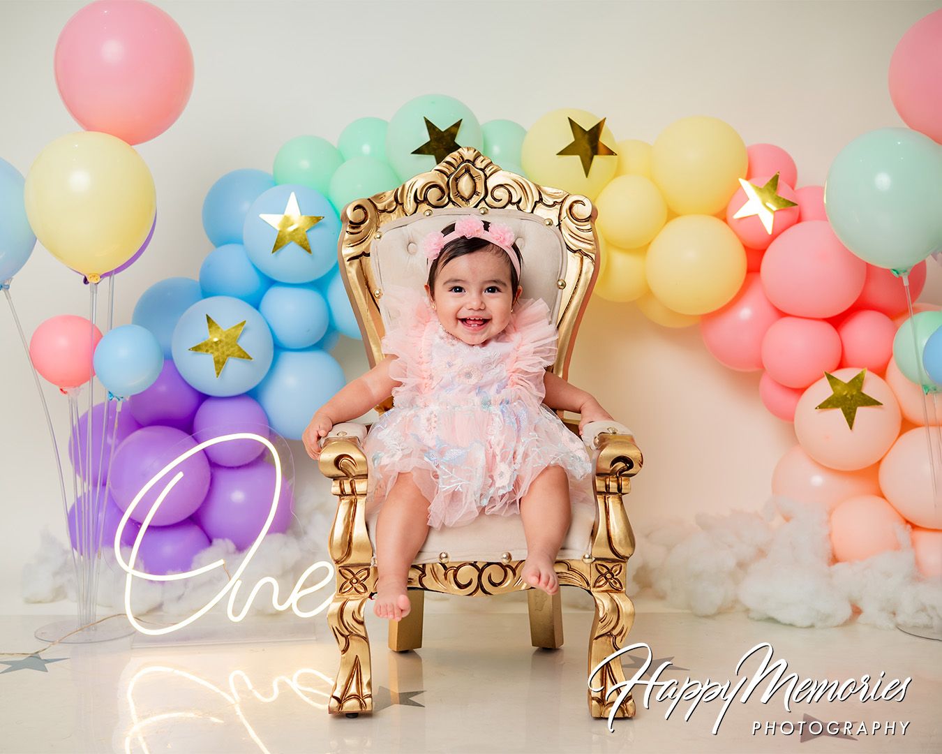 Colorful pastel balloon garland with gold star accents and decorative elements.