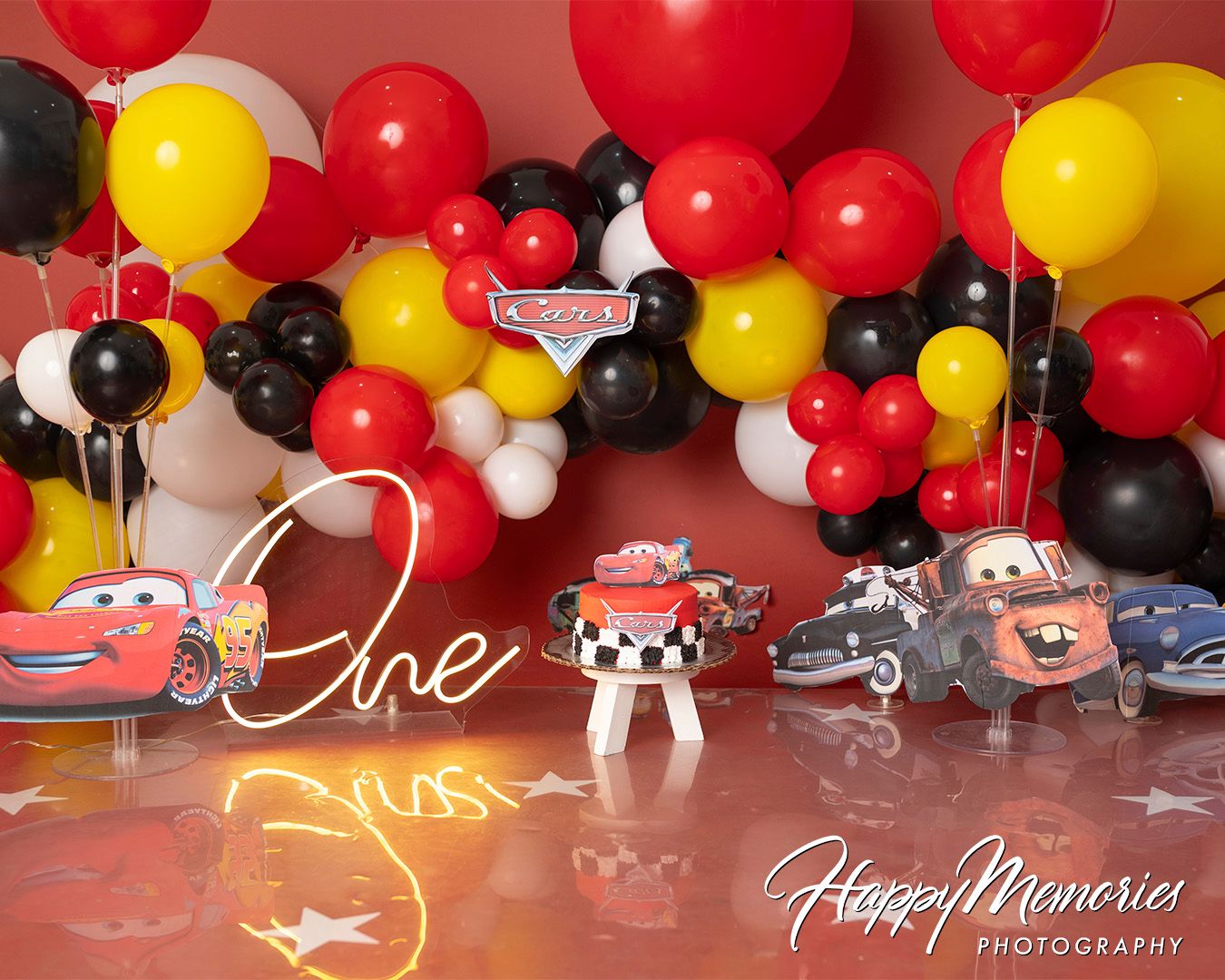 Mickey Mouse themed party backdrop with red, yellow and black balloon garland arrangement.