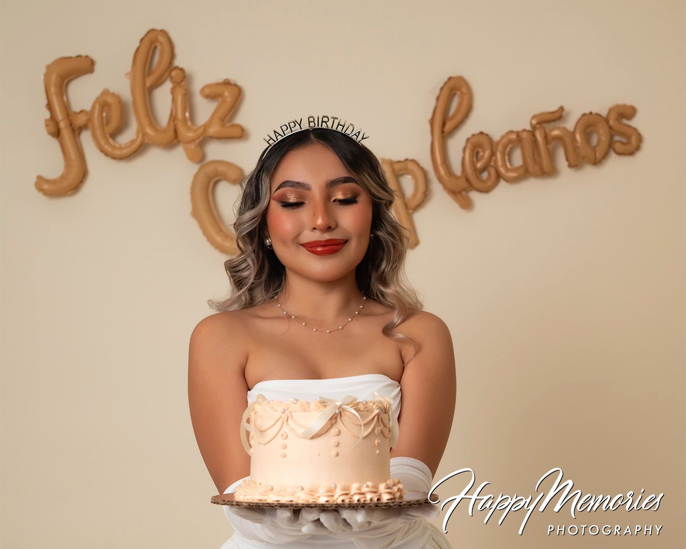 Elegant portrait session with bronze letter balloons and neutral background.