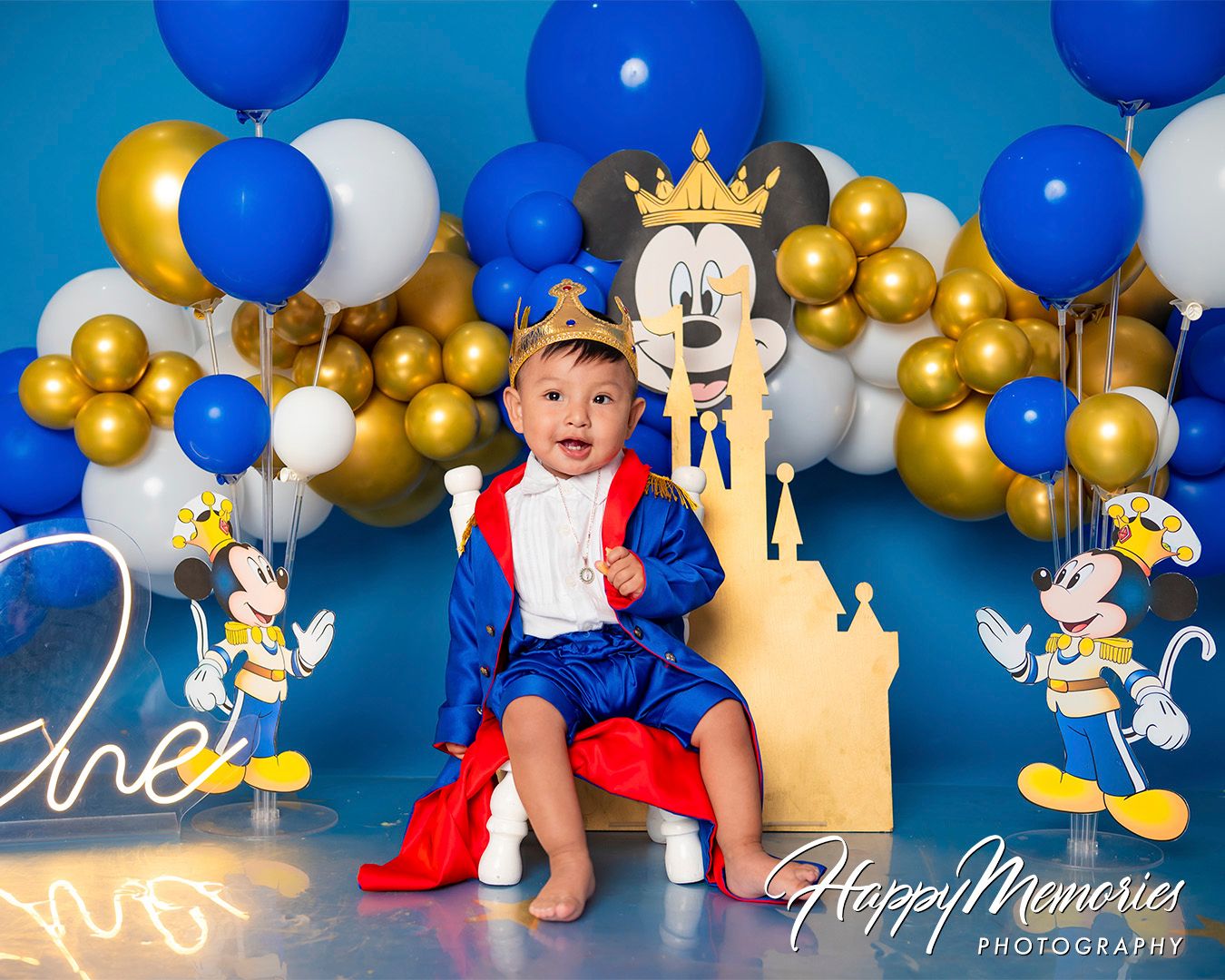 Festive birthday setup with blue and gold balloons, Mickey Mouse decorations, and royal theme elements.