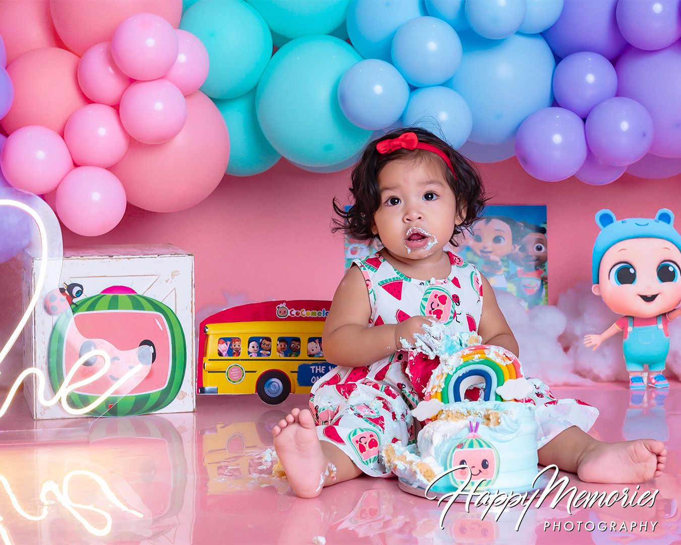 Colorful pink, blue and purple balloon decorations arranged in a festive party setting with birthday party elements.