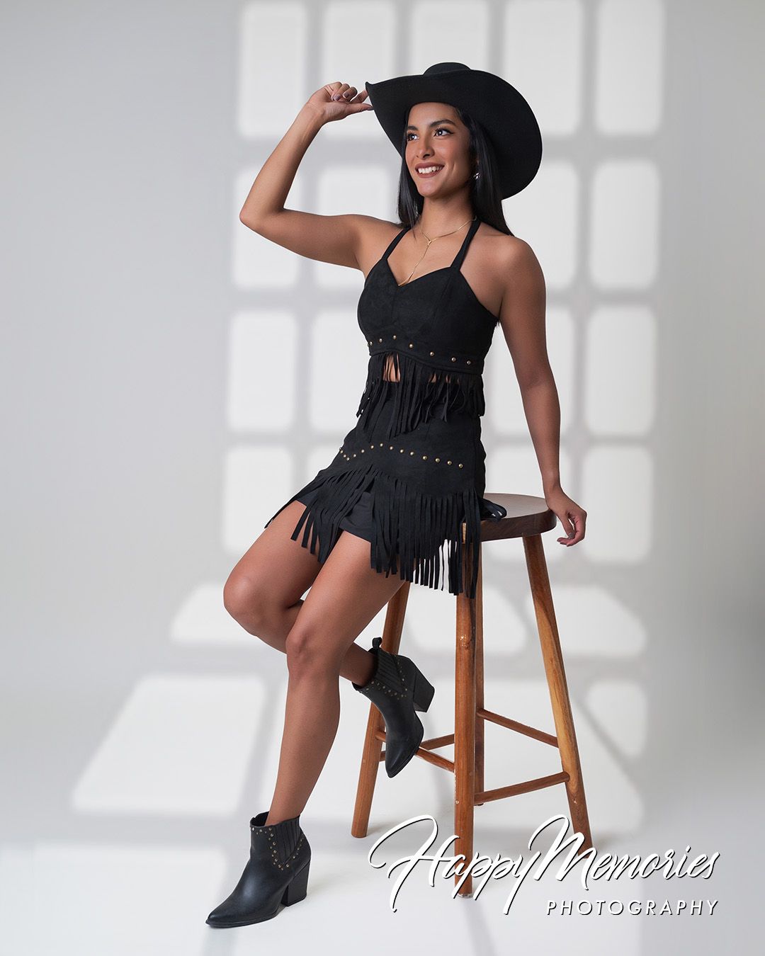 Fashion portrait series with black hat and boots in minimalist studio setting.