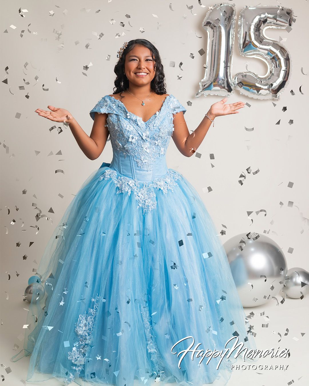 Sweet 15 celebration photoshoot with a flowing light blue ballgown and silver confetti.
