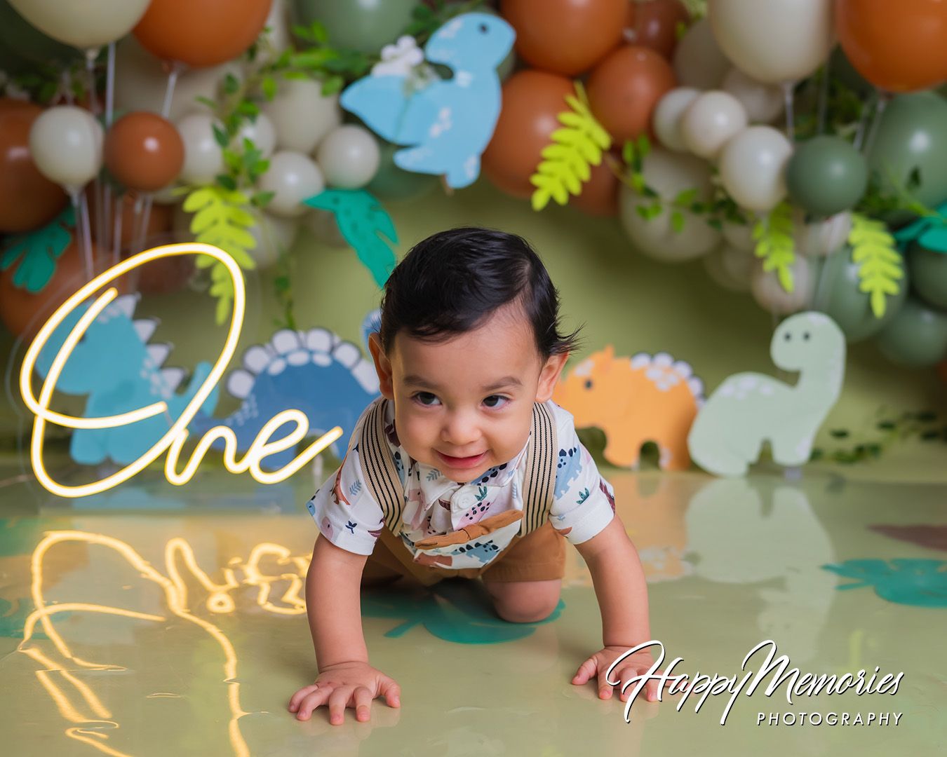 A festive birthday celebration scene with colorful balloons, green foliage decorations and party decor against a light background.
