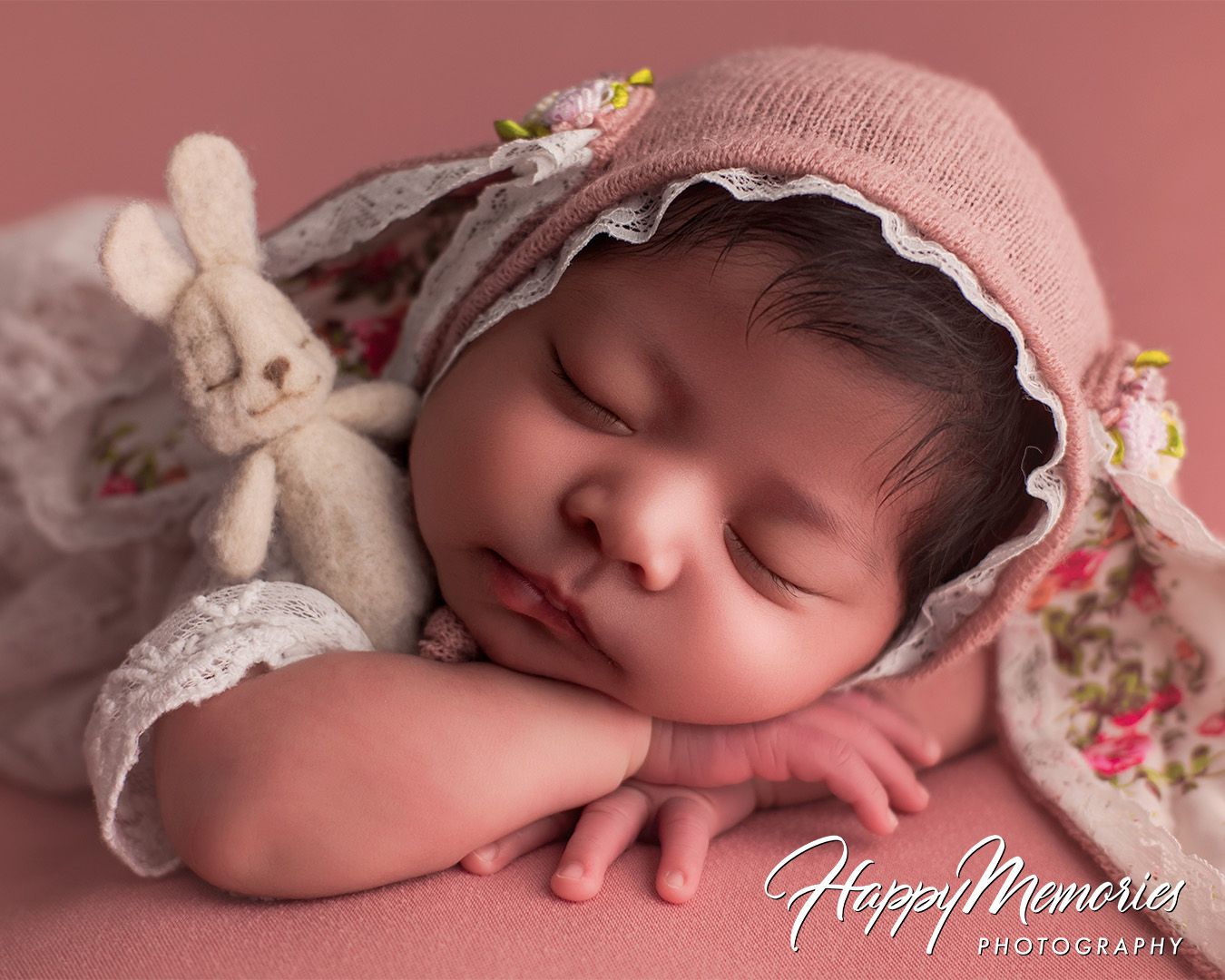 Delicate newborn photography collection with baby in pink tones and lace accessories.