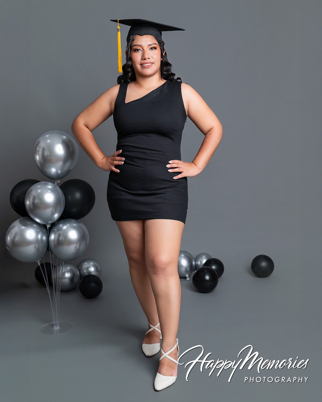 Studio graduation portraits with elegant black and silver balloon decorations.