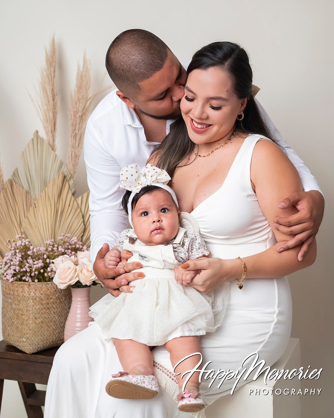 Family portrait series in white outfits showing tender moments with baby.